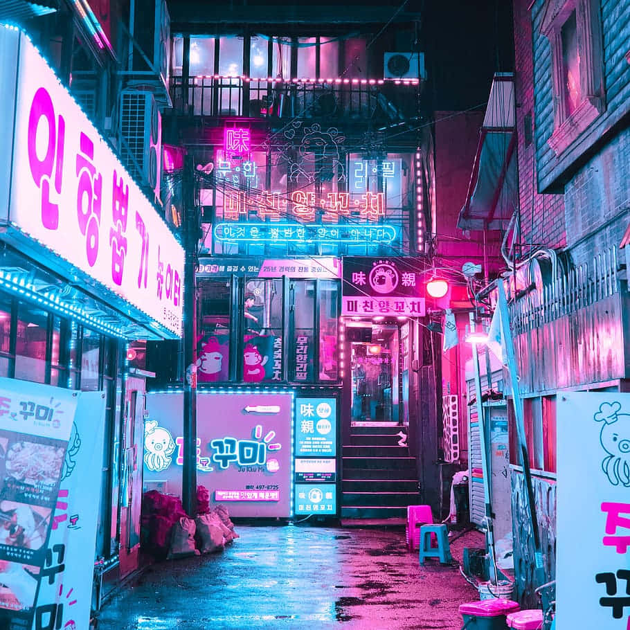 Blue And Pink Aesthetic Neon 桌布 壁紙 — 夜晚一條狹窄的霓虹燈小巷，鮮豔的粉紅色和藍色招牌倒映在濕漉漉的路面上。