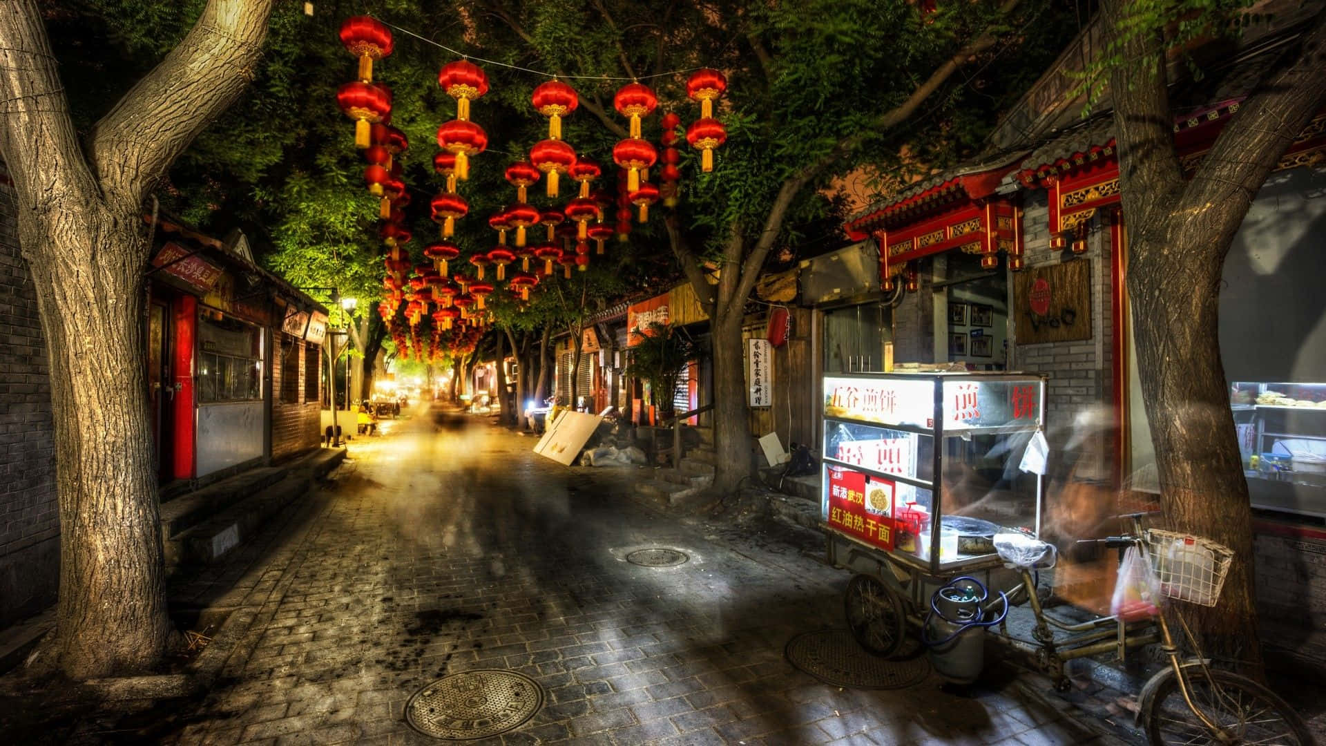 Road 桌布 壁紙 — 夜晚一條狹窄的鵝卵石小巷，被一串串發光的紅燈籠和溫暖的路燈照亮。