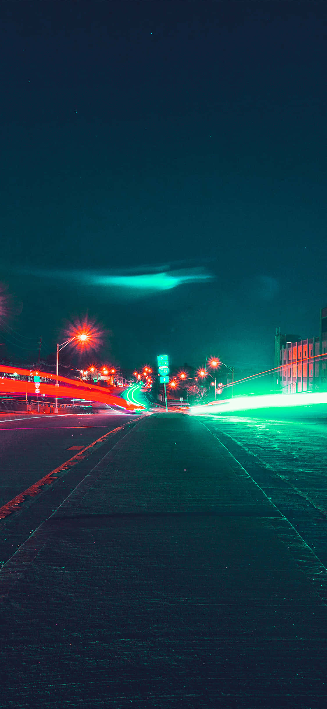 Street Light 桌布 壁紙 — 夜晚一條被霓虹燈照亮的城市道路，在黑暗的天空下，移動車輛留下紅色和綠色的光軌。