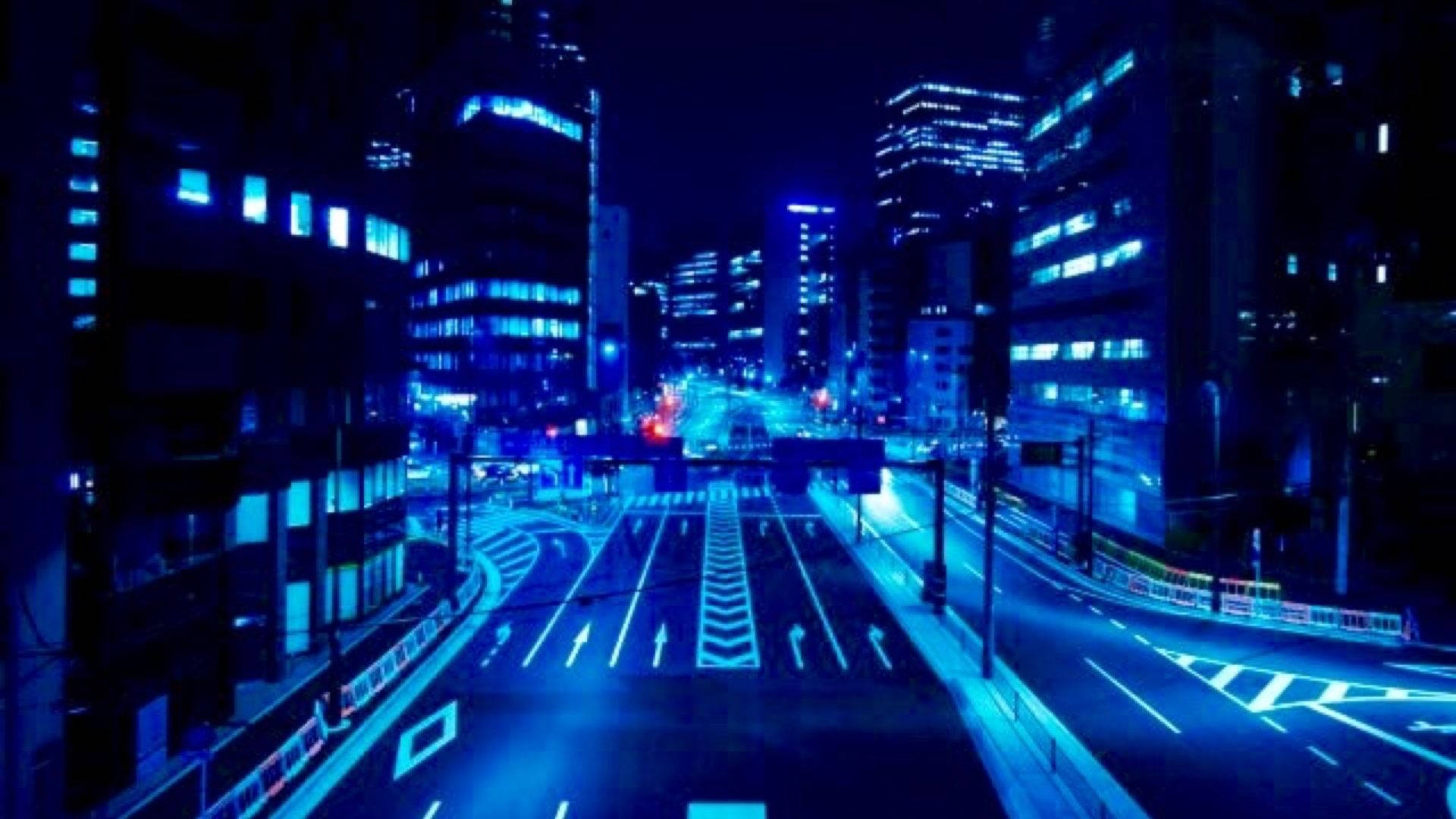 霓虹藍動畫 桌布 壁紙 — 夜晚一條被霓虹藍光照亮的城市街道，帶有發光的道路標記和高聳的建築物。
