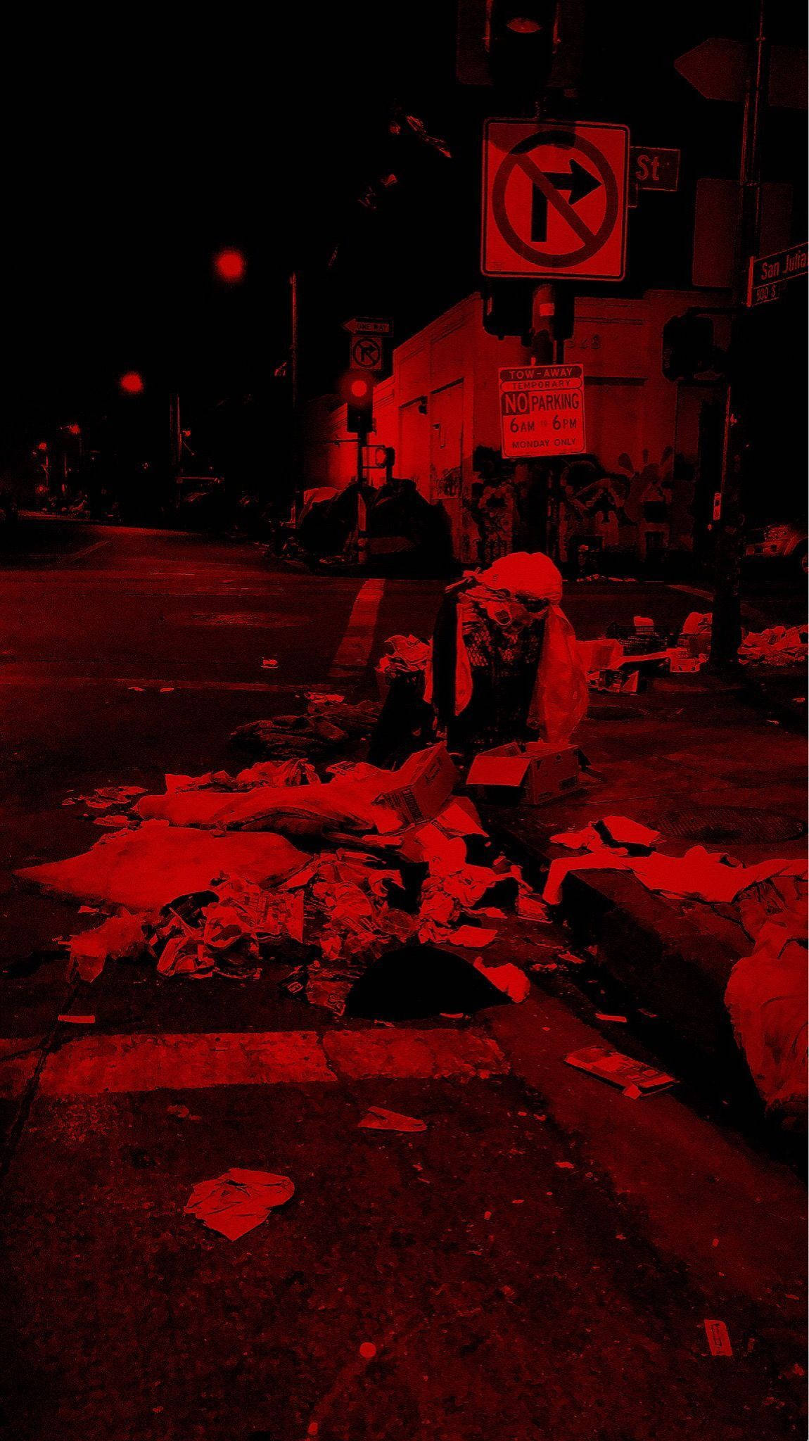 Dark Aesthetic iPhone 桌布 壁紙 — 夜晚一條骯髒的城市街道，籠罩在詭異的紅光中，散落著垃圾和一個禁止停車標誌。
