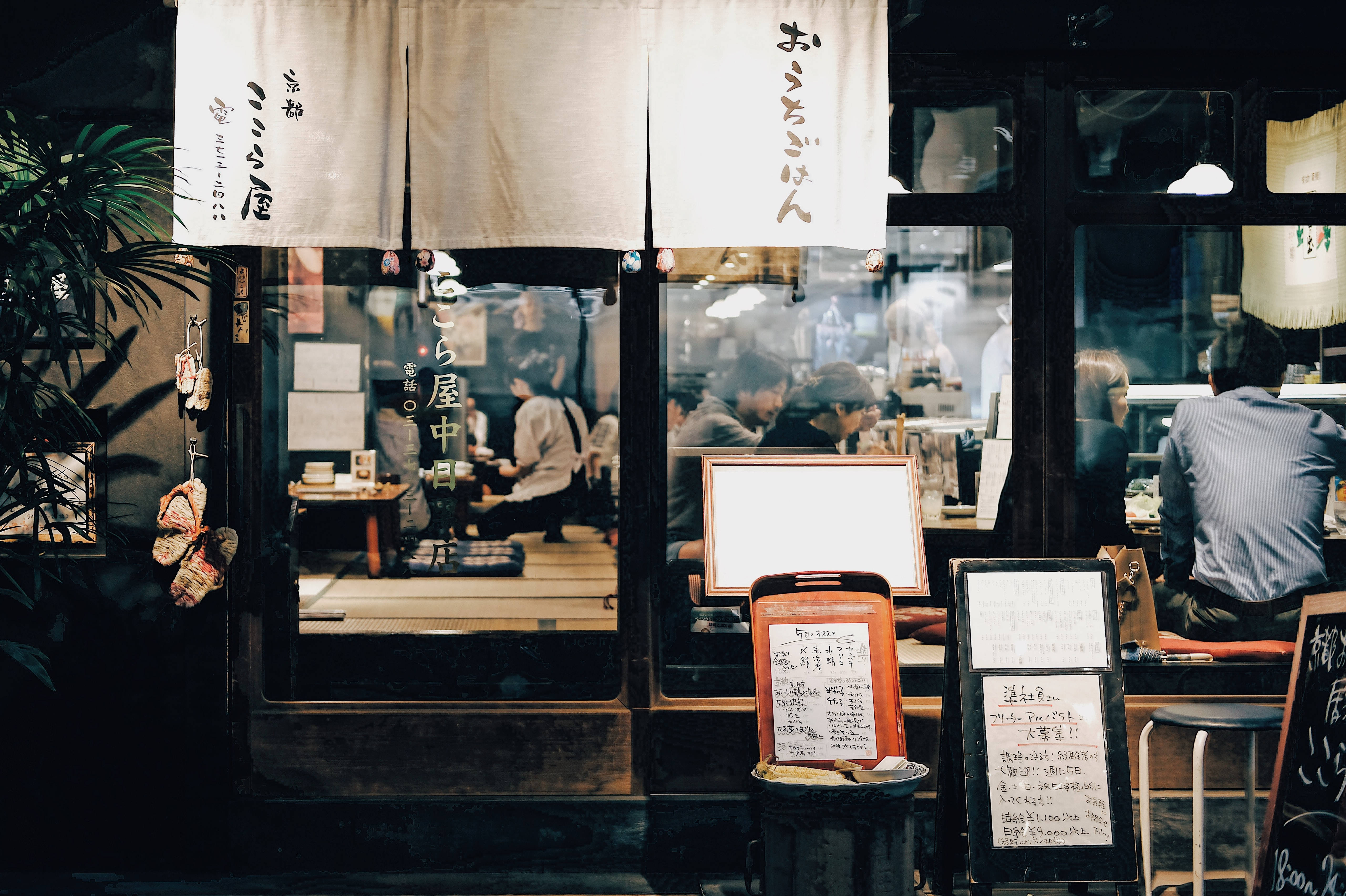 Restaurant 桌布 壁紙 — 夜晚一間舒適的日本餐廳，室內燈光溫暖，有顧客在內用餐。