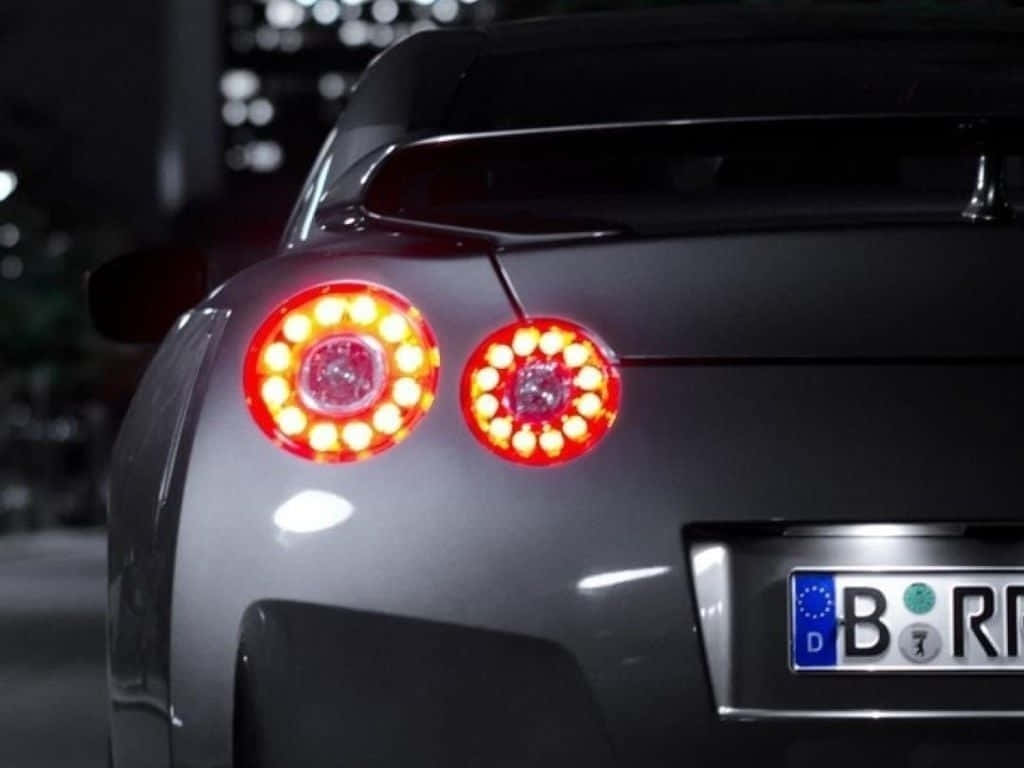 夜晚城市中，一輛時尚灰色跑車帶有發光的紅色尾燈。 — Toyota Supra Mk4 壁紙