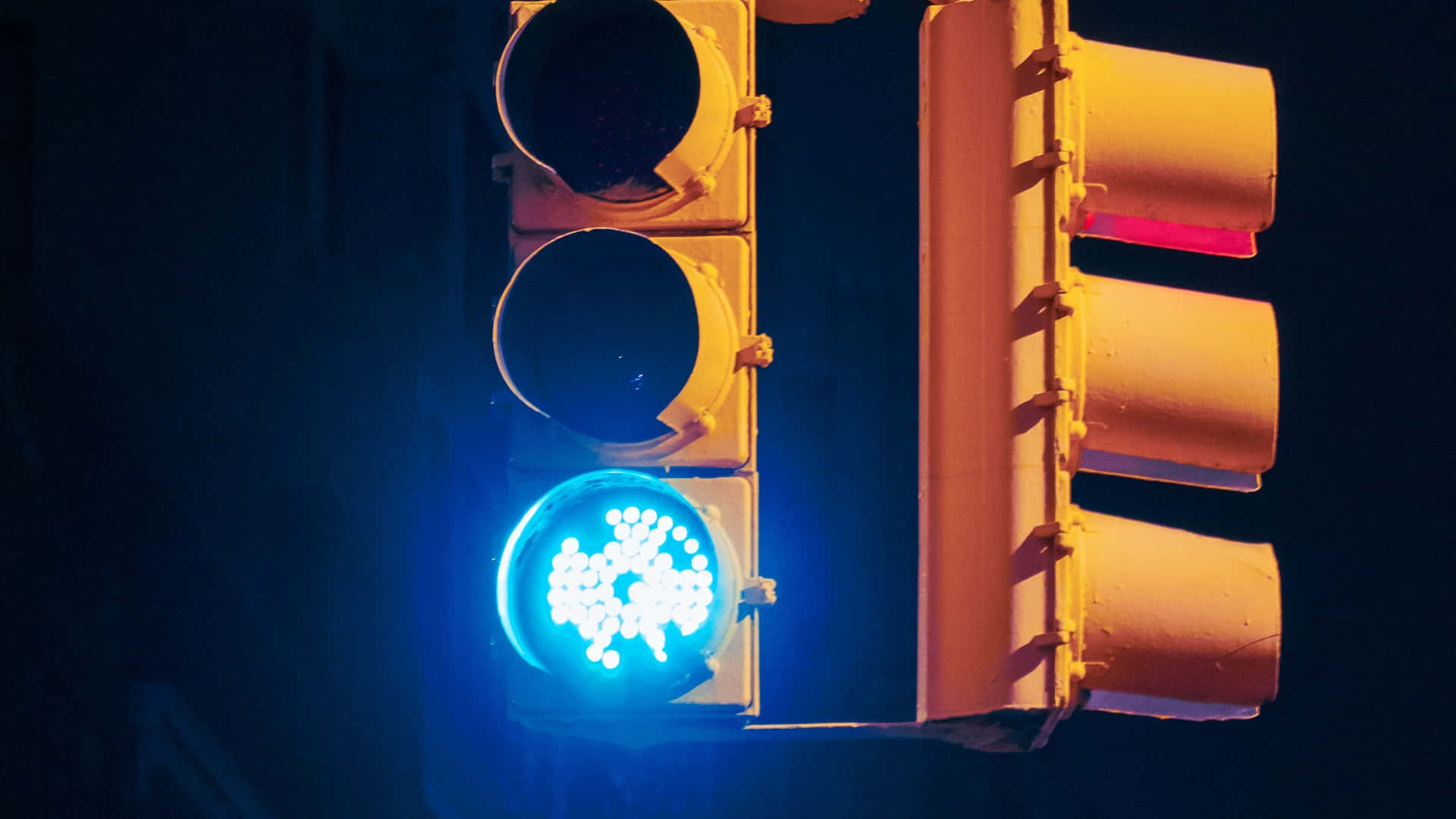Stop Light 桌布 壁紙 — 夜晚交通號誌的特寫，藍色燈光在黑暗背景中亮起。