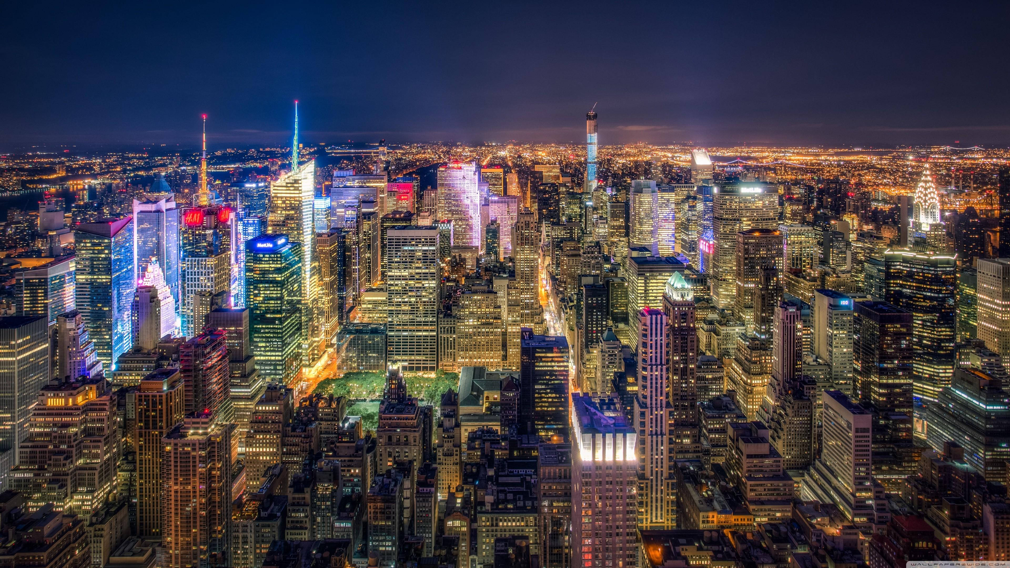 Skyscraper 桌布 壁紙 — 夜晚充滿活力的城市天際線鳥瞰圖，高樓大廈燈火通明，街道閃爍。