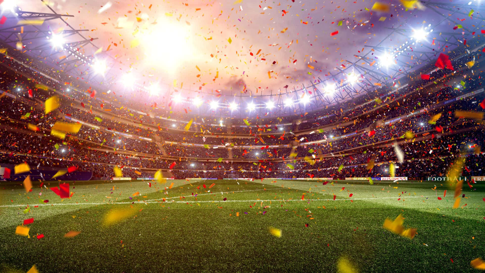 Soccer Stadium 桌布 壁紙 — 夜晚充滿活力的足球場，擠滿歡呼的球迷，在明亮的球場燈光下飄落五彩紙屑。