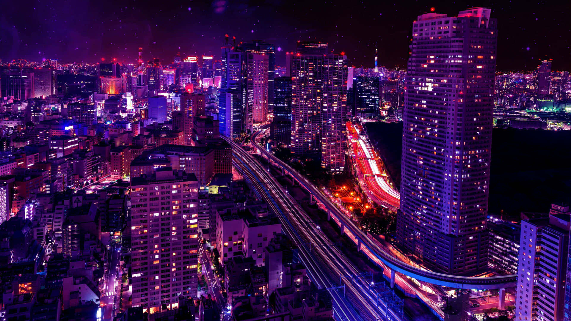 City Lights 桌布 壁紙 — 夜晚充滿活力的霓虹燈城市景觀，閃爍的摩天大樓和高架高速公路上的車流光跡。