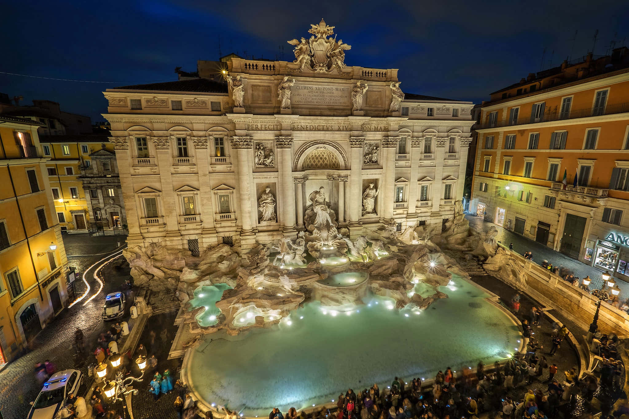 Rome 桌布 壁紙 — 夜晚在繁華的歐洲廣場上，一座宏偉的照明噴泉，配有古典雕像和流動的水。