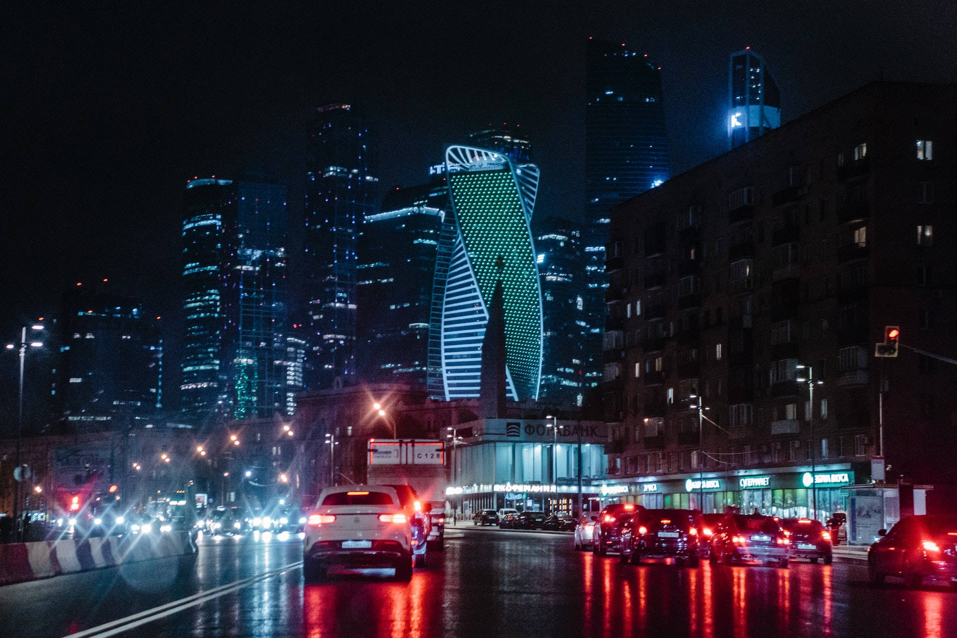 Night Aesthetic 桌布 壁紙 — 夜晚城市景觀，發光的摩天大樓和潮濕的街道反射紅色汽車尾燈。
