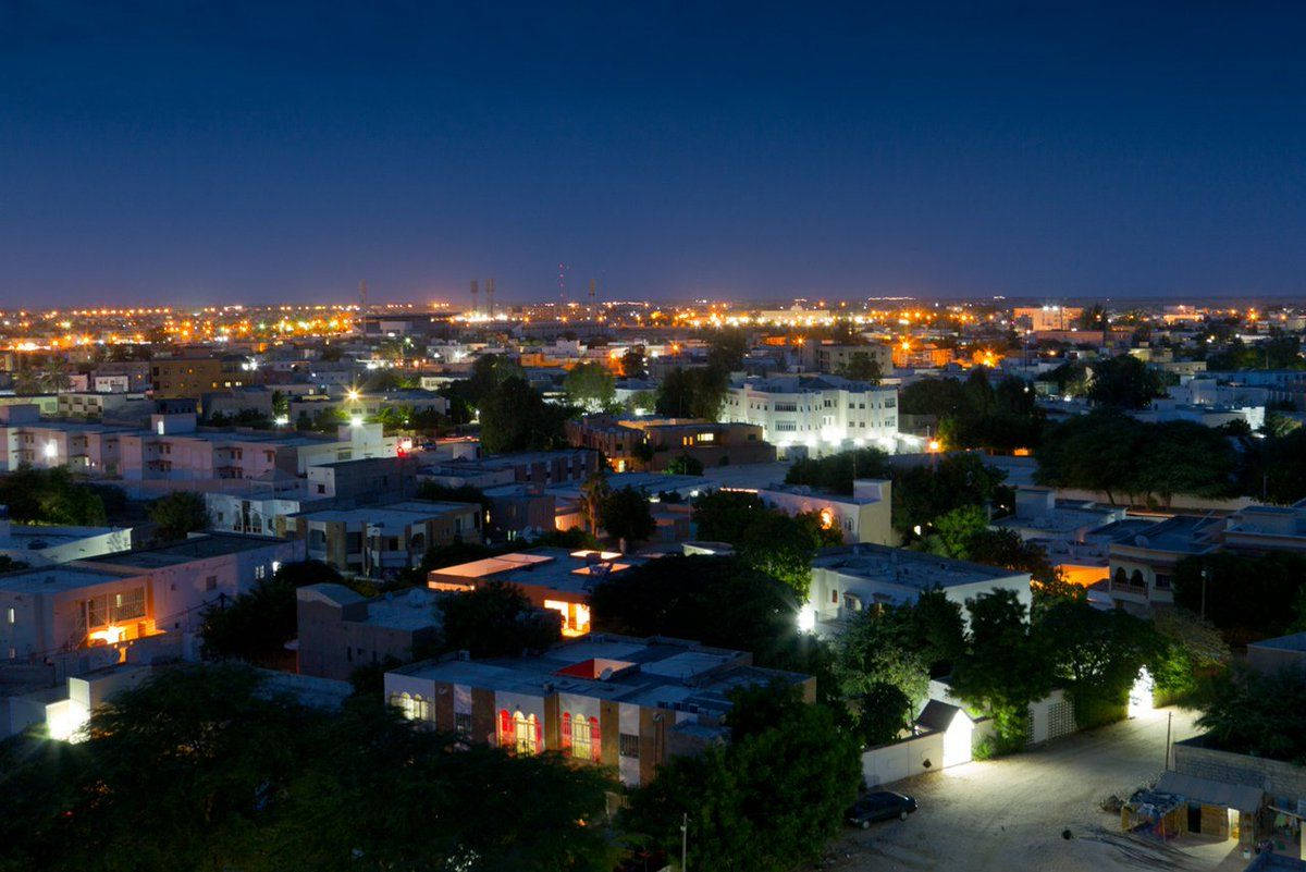 夜空 桌布 壁紙 — 夜晚城市的鳥瞰圖，閃爍的街燈和溫暖的家居窗戶映襯著深藍色的天空。