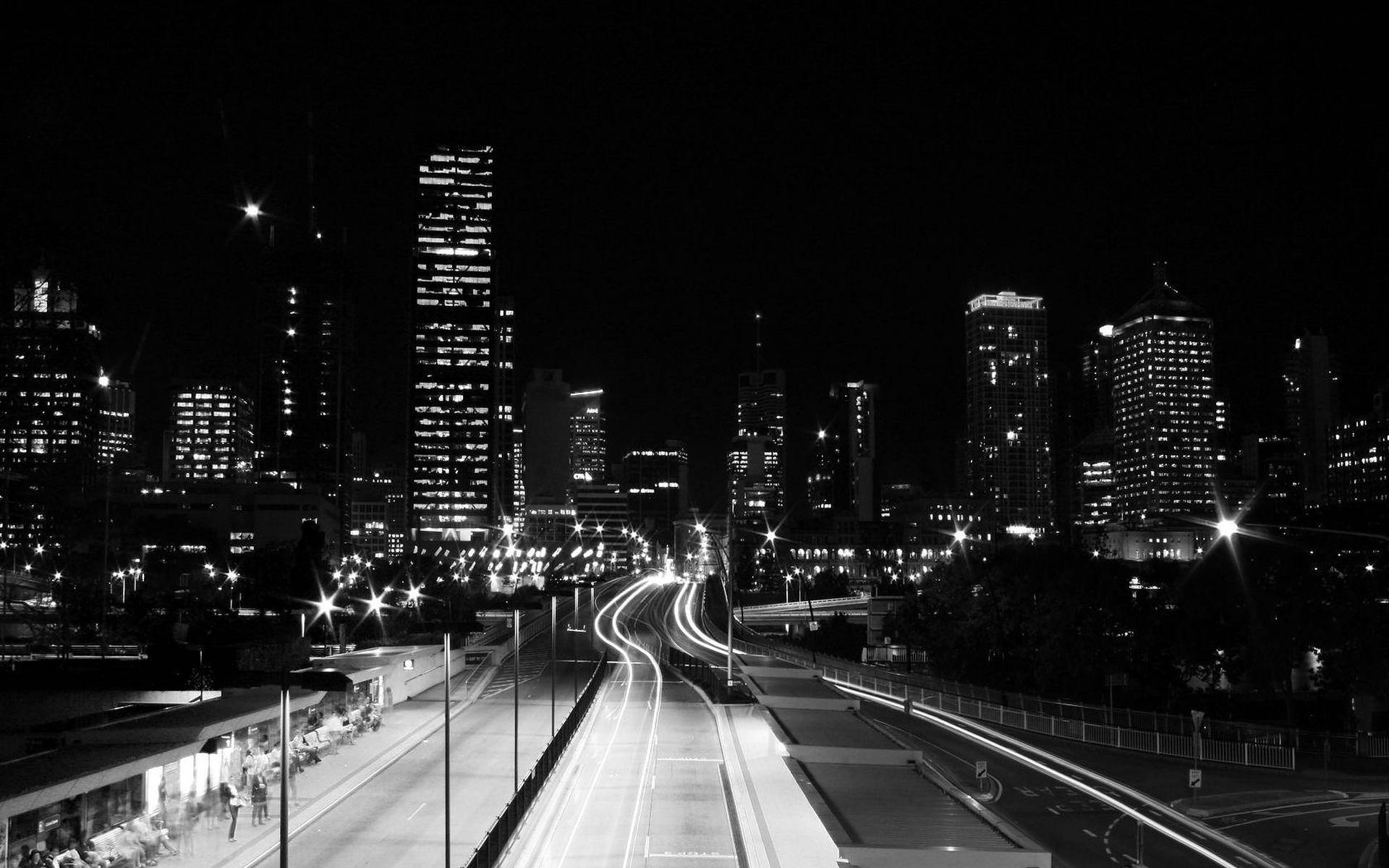夜晚城市景觀，高速公路上的汽車燈光軌跡和亮燈的摩天大樓。 — 黑暗城市 壁紙