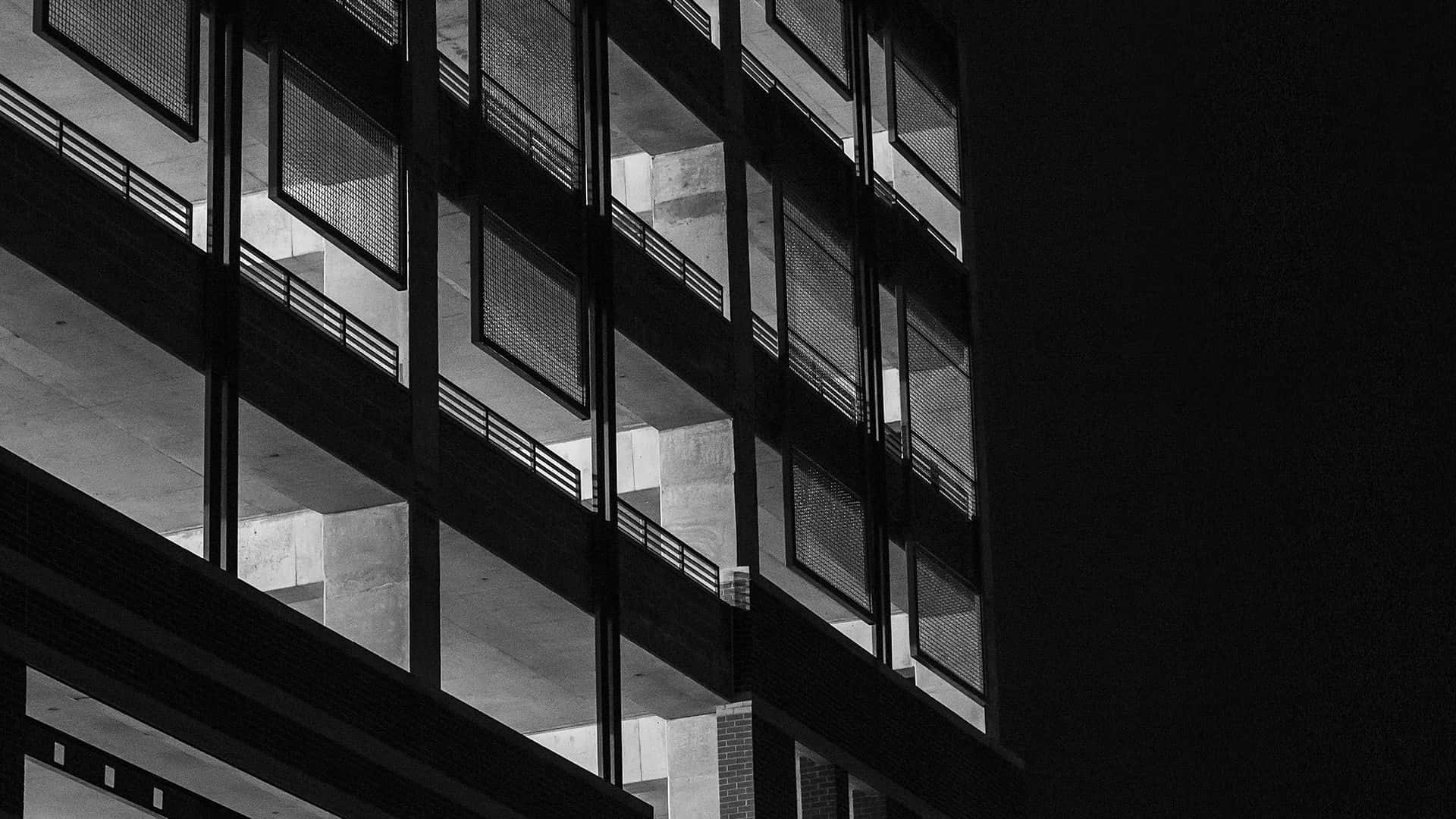 黑色美學 桌布 壁紙 — 夜晚多層混凝土建築物的鮮明黑白建築照片，帶有強烈的幾何陰影。