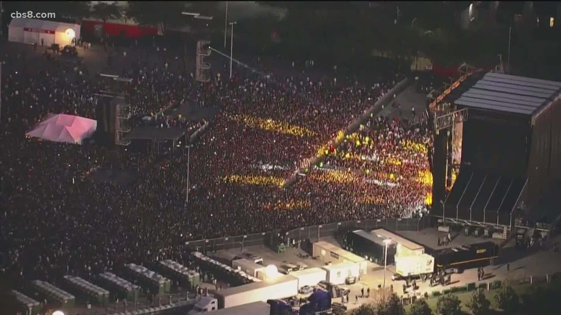 Travis Scott Concert 桌布 壁紙 — 夜晚大規模音樂會人群的鳥瞰圖，發光的黃色光圖案在黑暗中形成形狀。