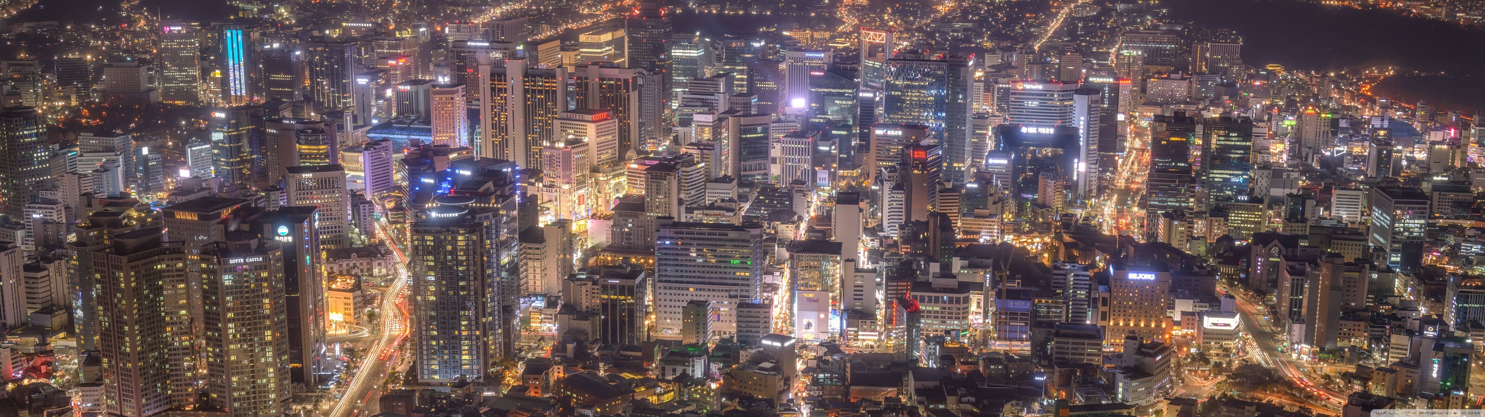 5120x1440 壁紙 桌布 壁紙 — 夜晚廣闊城市的空中景觀，閃爍的摩天大樓和明亮的街道。
