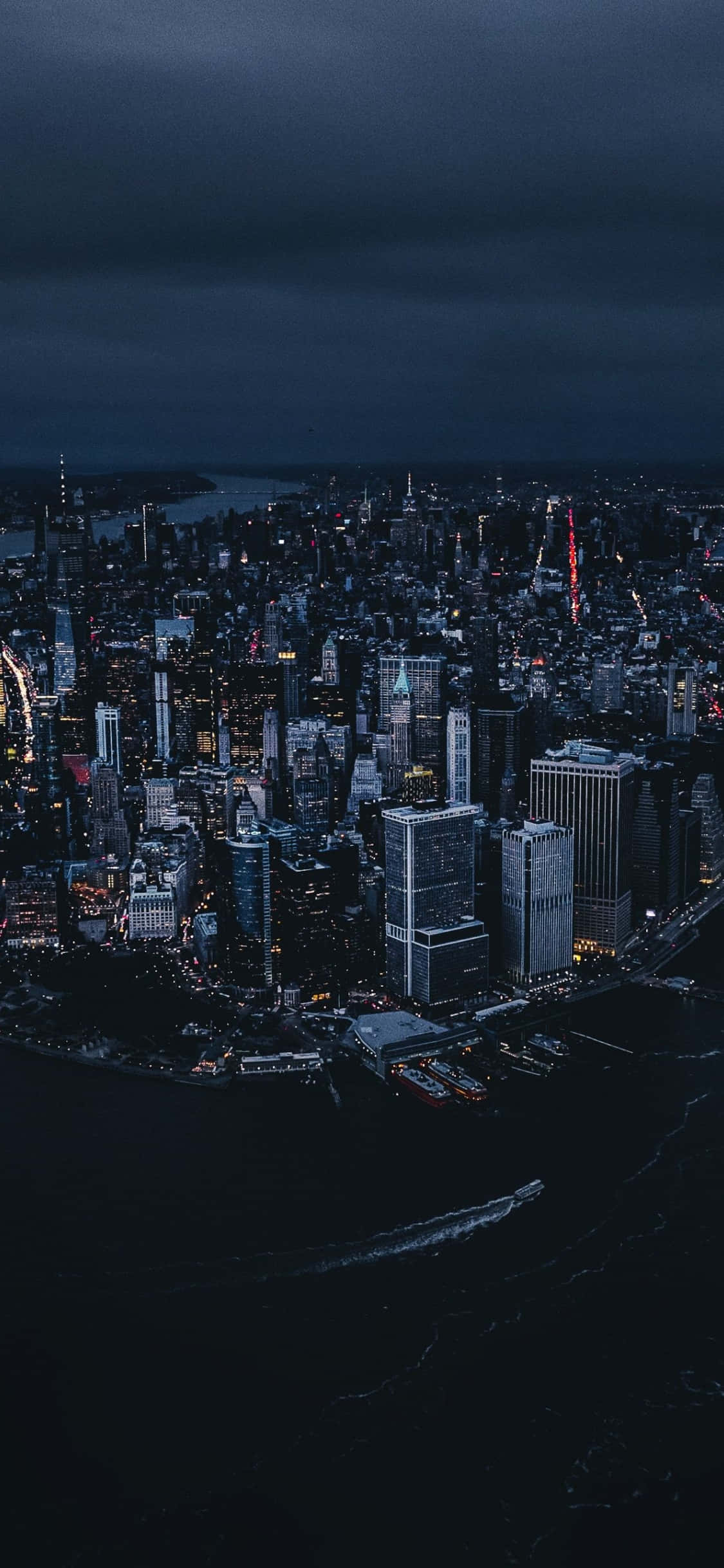New York 桌布 壁紙 — 夜晚廣闊城市的鳥瞰圖，閃爍的摩天大樓和頭頂的烏雲。