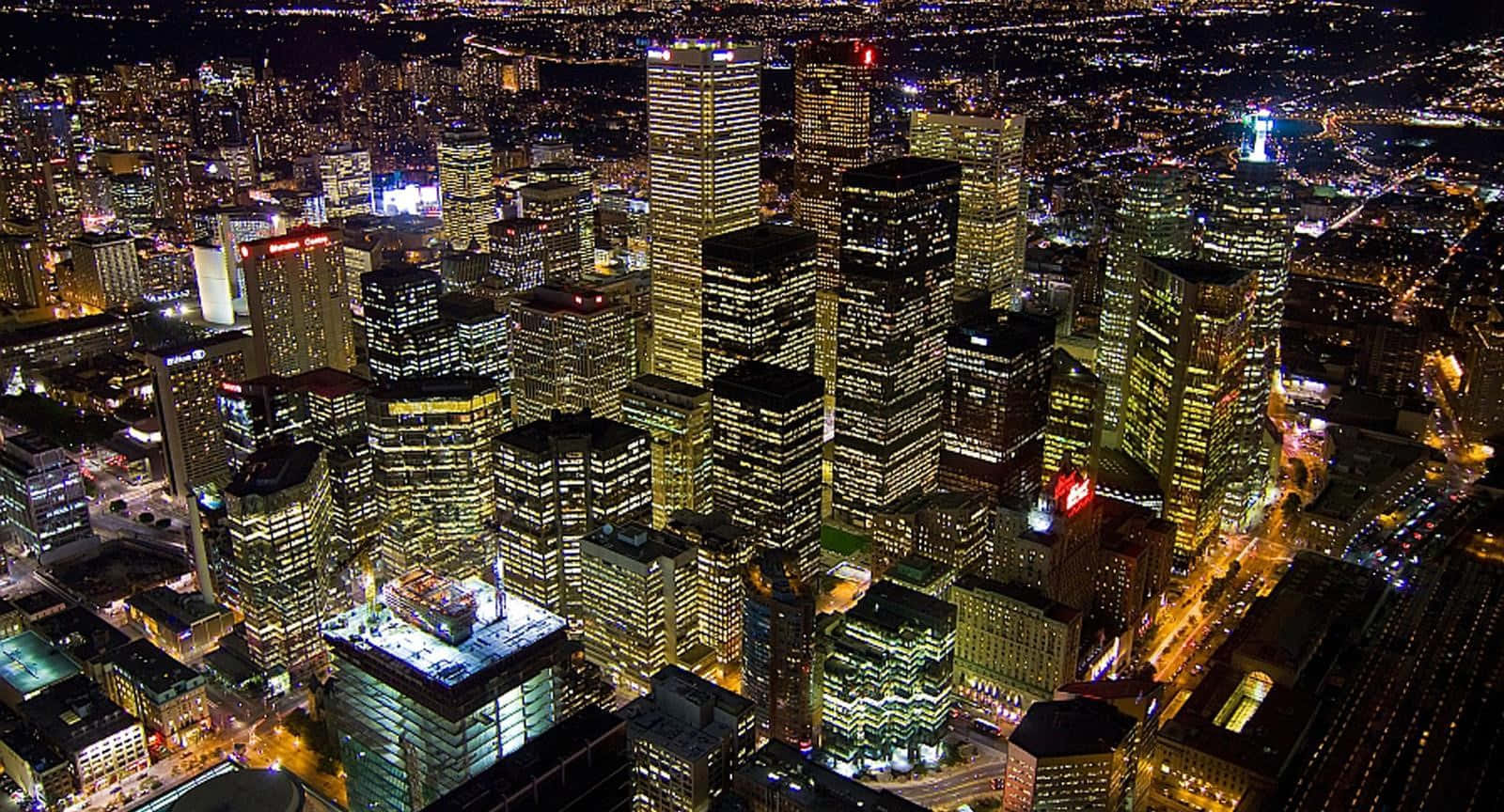 Toronto 桌布 壁紙 — 夜晚廣闊城市的鳥瞰圖，高聳的摩天大樓散發著溫暖的黃色和白色燈光。