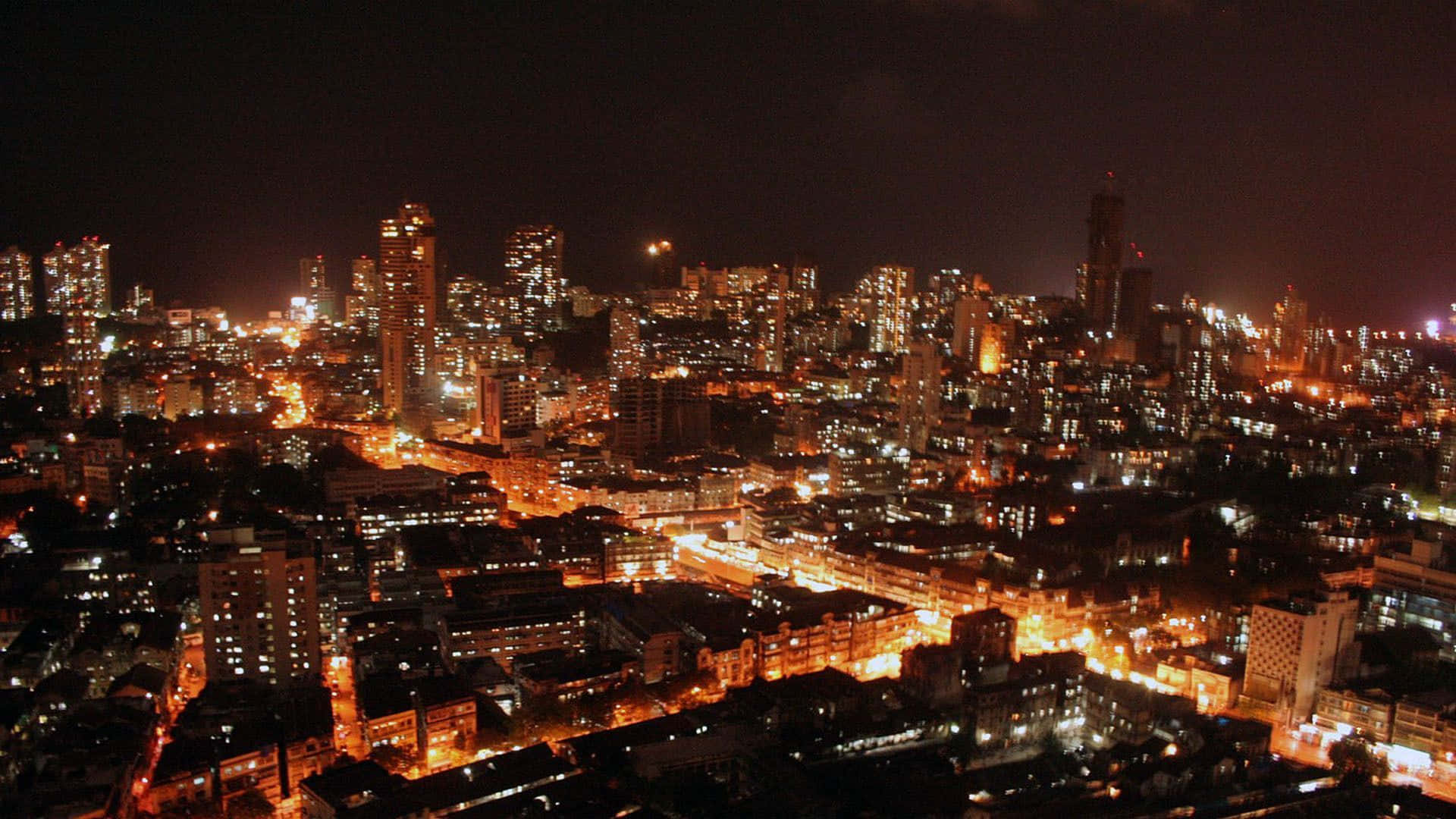 Mumbai 桌布 壁紙 — 夜晚廣闊的城市景觀，閃爍的摩天大樓和街燈照亮密集的城市建築。