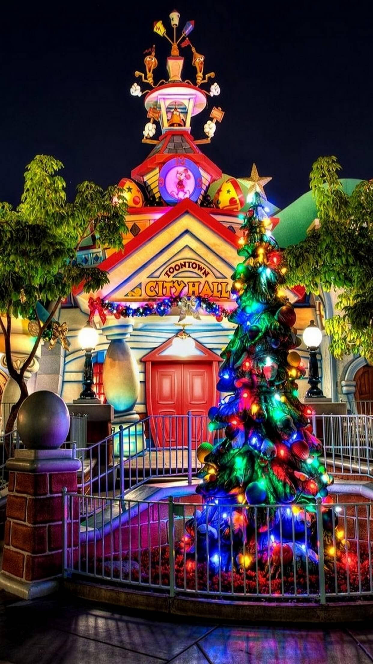 彩色動圖 桌布 壁紙 — 夜晚明亮照明的Toontown市政廳，裝飾著色彩繽紛的聖誕樹和節日裝飾。