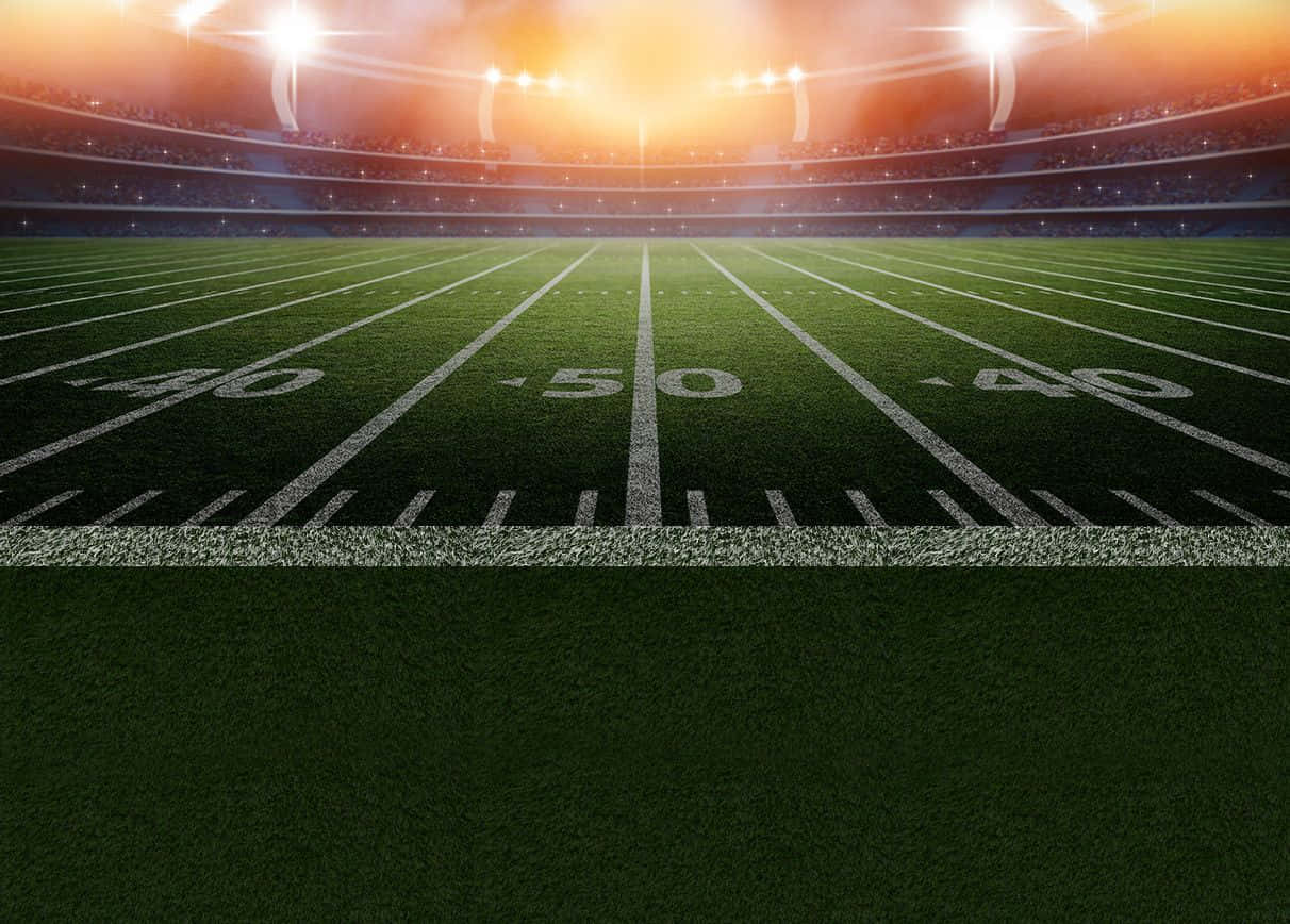 Football Field 桌布 壁紙 — 夜晚明亮球場燈光下，足球場中央的戲劇性景觀，看台空無一人。