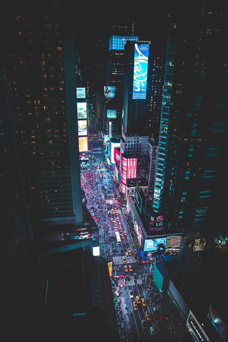 桌布 壁紙 — 夜晚時代廣場的鳥瞰圖，下方有發光的廣告牌和擁擠的街道。