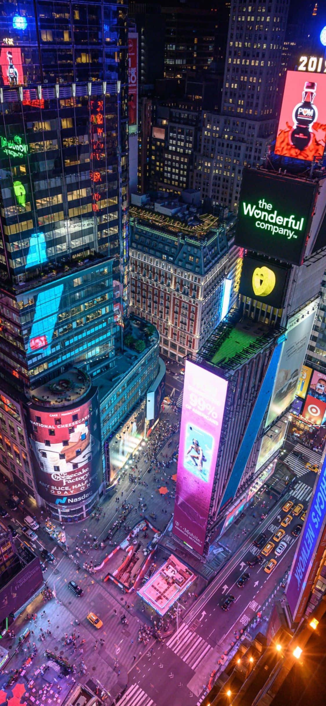 iPhone Xs Ny City 桌布 壁紙 — 夜晚時代廣場的鳥瞰圖，發光的廣告牌和下方擁擠的街道。