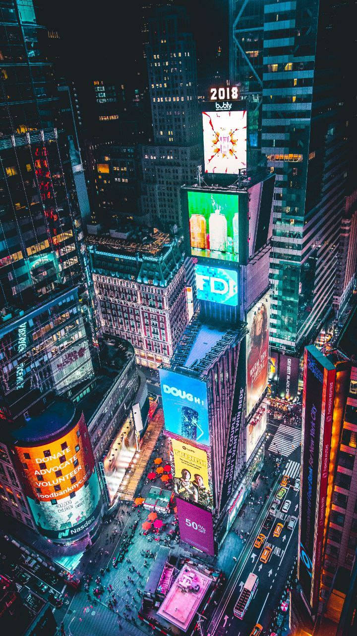 iPhone 桌布 壁紙 — 夜晚時代廣場的鳥瞰圖，閃爍的廣告牌和繁忙的街道被高聳的摩天大樓環繞。