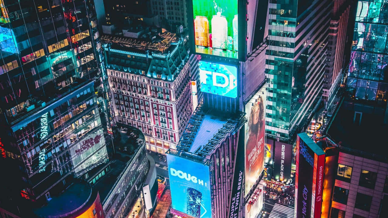 720p Ny City 桌布 壁紙 — 夜晚時代廣場的鳥瞰圖，高聳的建築物閃爍著充滿活力的數位廣告看板和霓虹燈。