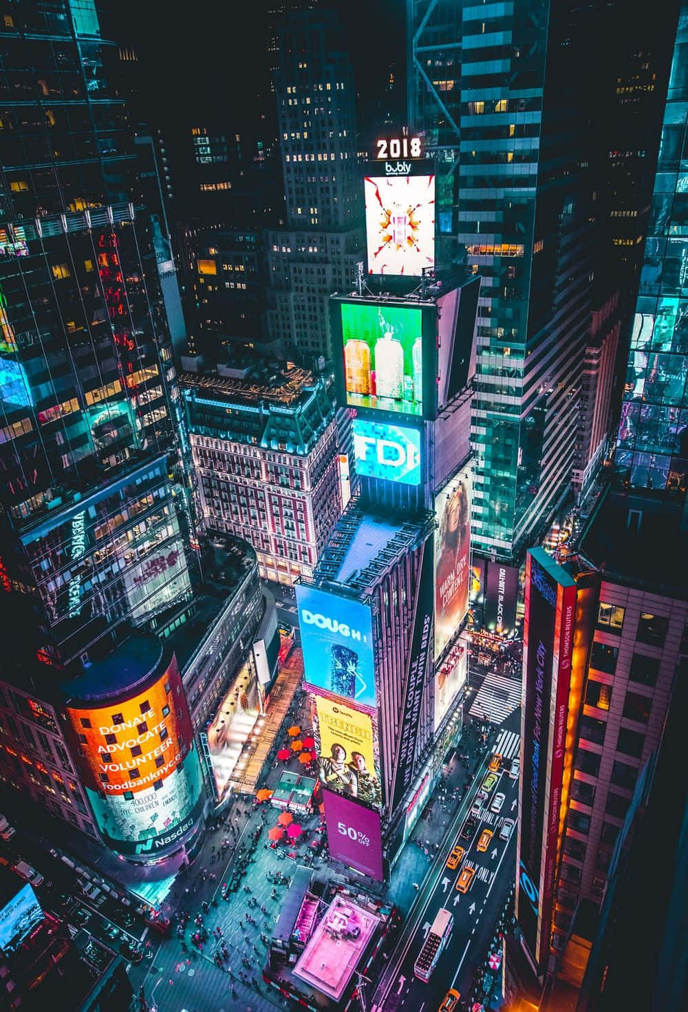 New York 桌布 壁紙 — 夜晚時報廣場的鳥瞰圖，高聳的摩天大樓閃爍著鮮豔的數位廣告牌，下方街道繁忙。