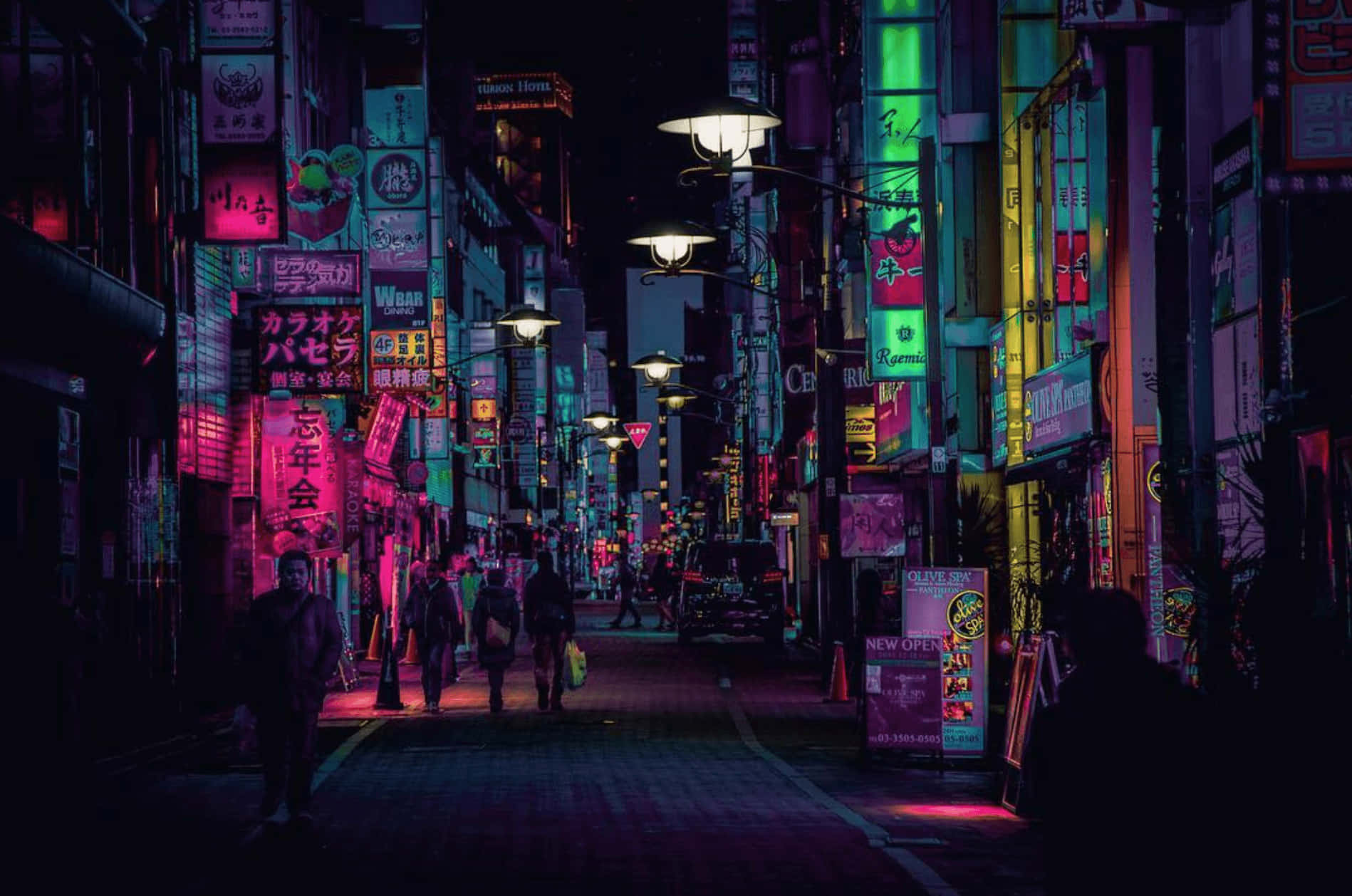 日本 桌布 壁紙 — 夜晚東京一條狹窄小巷，沐浴在鮮豔的粉紅、綠色和藍色霓虹燈招牌中，在潮濕的路面上投射出色彩繽紛的倒影。