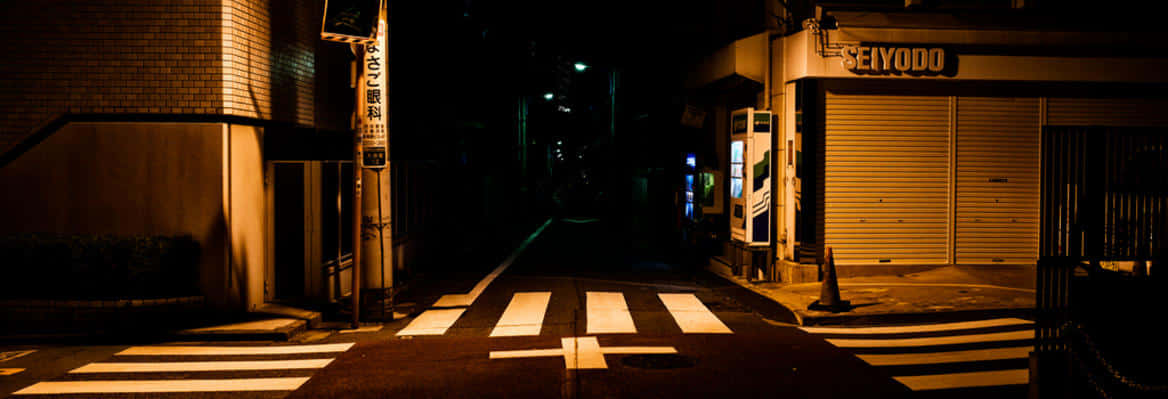 Dark Crossroad 桌布 壁紙 — 夜晚東京一條狹窄小巷，溫暖的路燈在斑馬線上投下長長的影子。