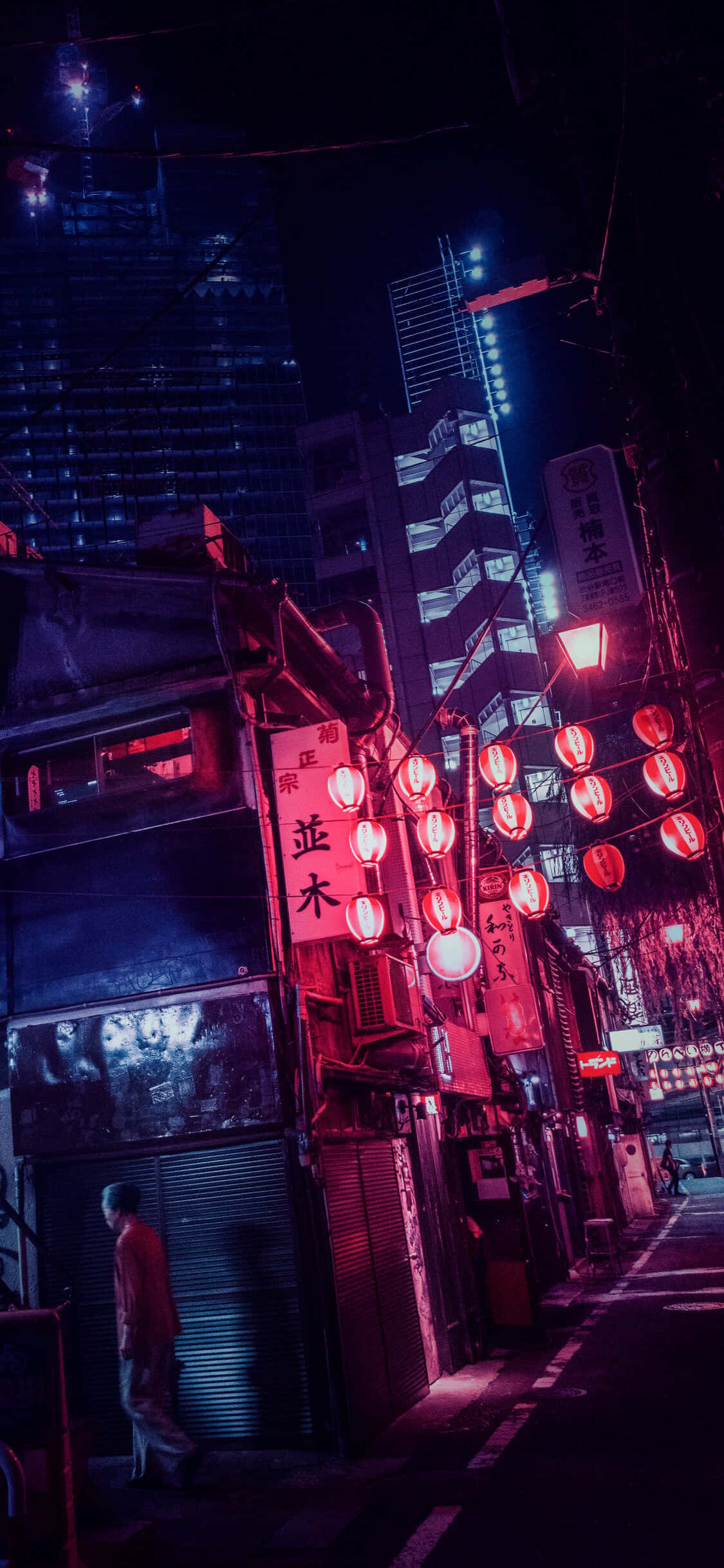 日式粉紅 桌布 壁紙 — 夜晚東京一條狹窄小巷，被鮮豔的紅色燈籠和霓虹招牌照亮，背後是高聳的摩天大樓。