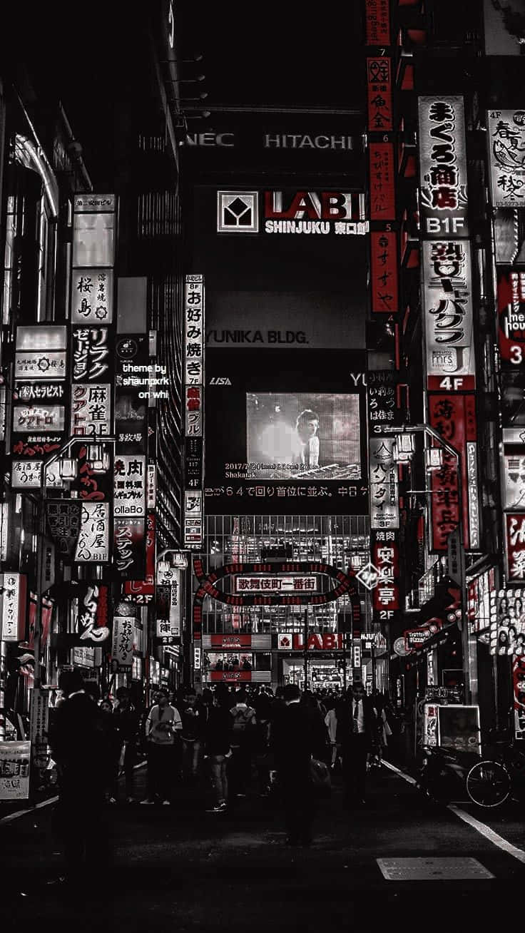 桌布 壁紙 — 夜晚東京一條狹窄的小巷，被發光的霓虹燈招牌照亮，擠滿了行人。