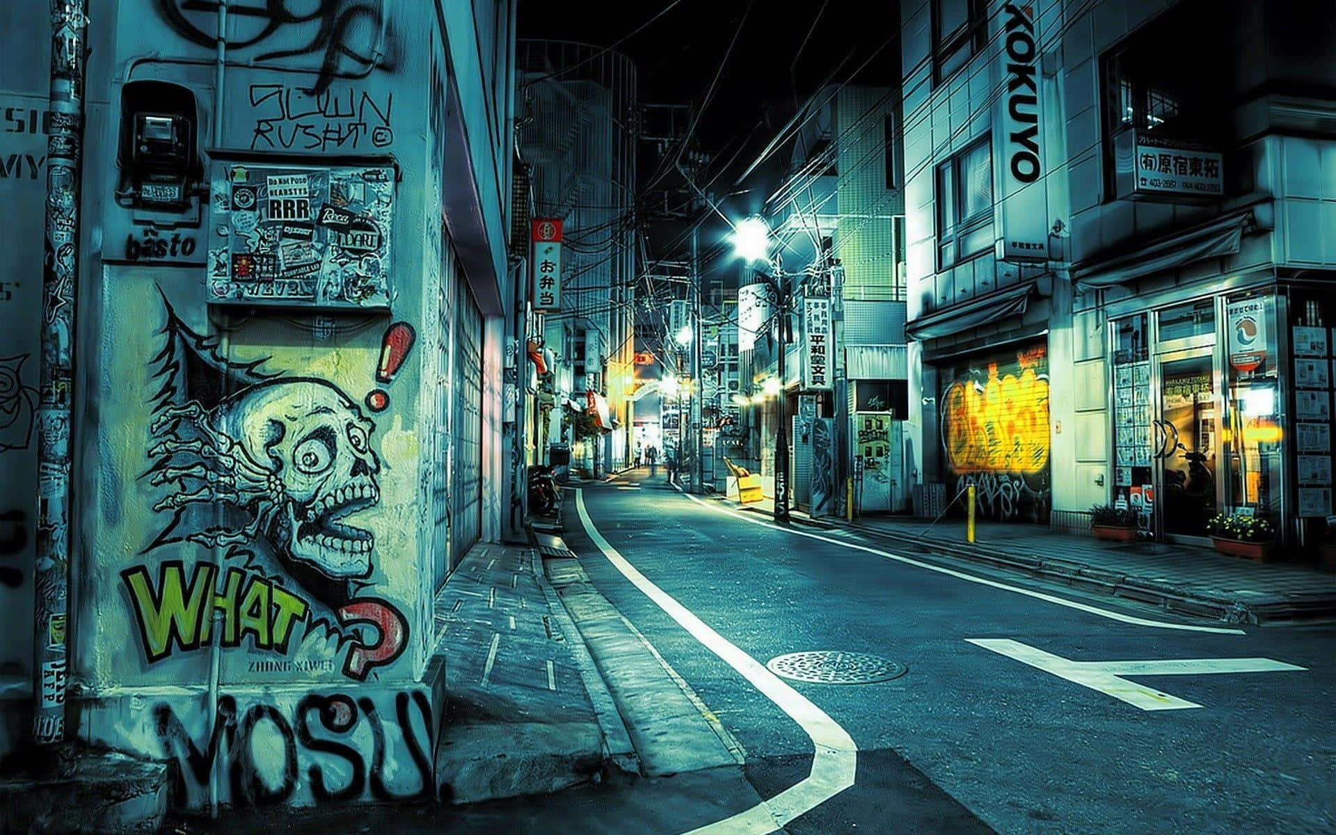 Urban 桌布 壁紙 — 夜晚東京一條霓虹燈照亮的小巷，牆上佈滿塗鴉，發光的街燈投下長長的影子。
