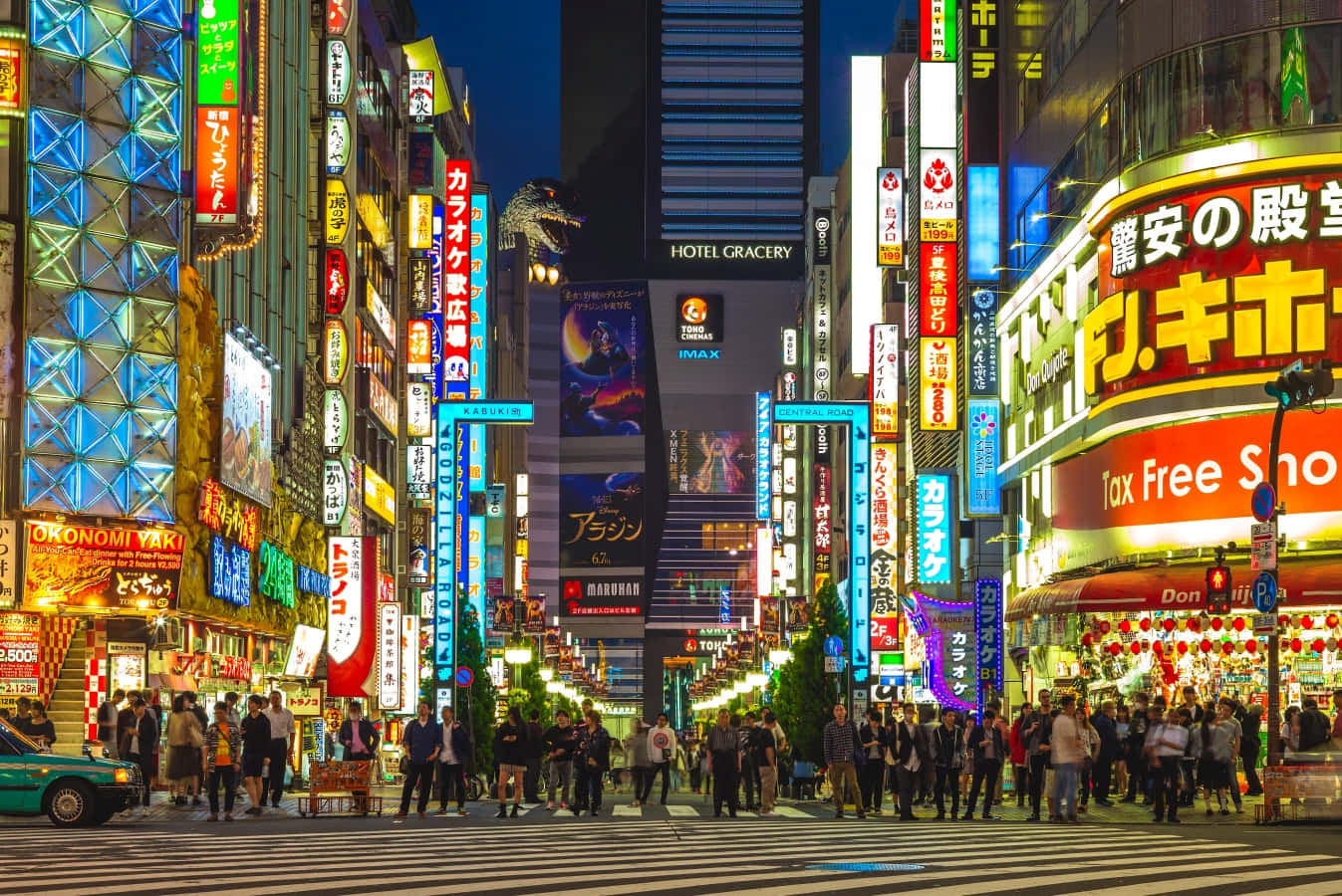 Night Street 桌布 壁紙 — 夜晚東京充滿活力的霓虹燈街道，人群穿過繁忙的十字路口，周圍是高聳的發光廣告牌和標誌。