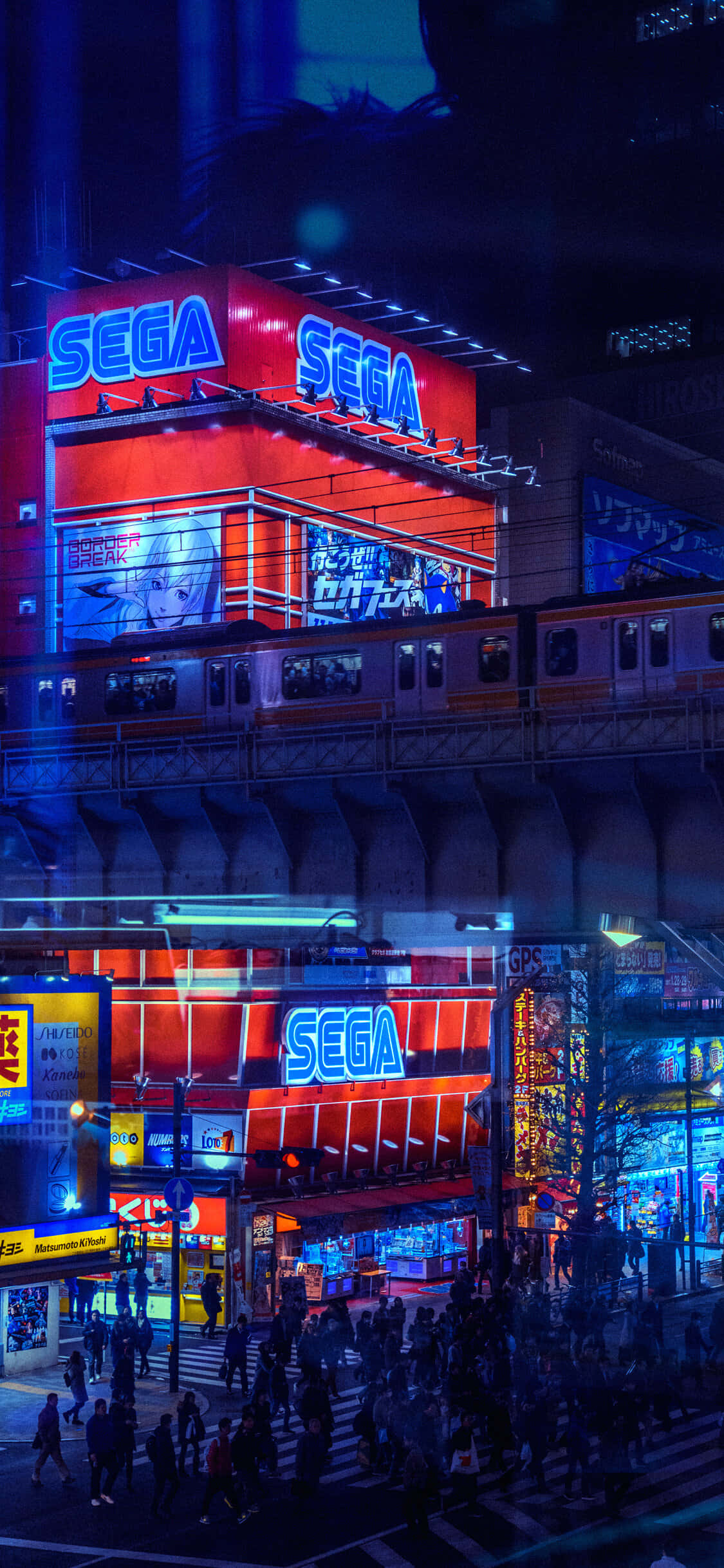 動漫城市 桌布 壁紙 — 夜晚東京充滿活力的霓虹燈街道，發光的SEGA遊戲機招牌和上方經過的火車。