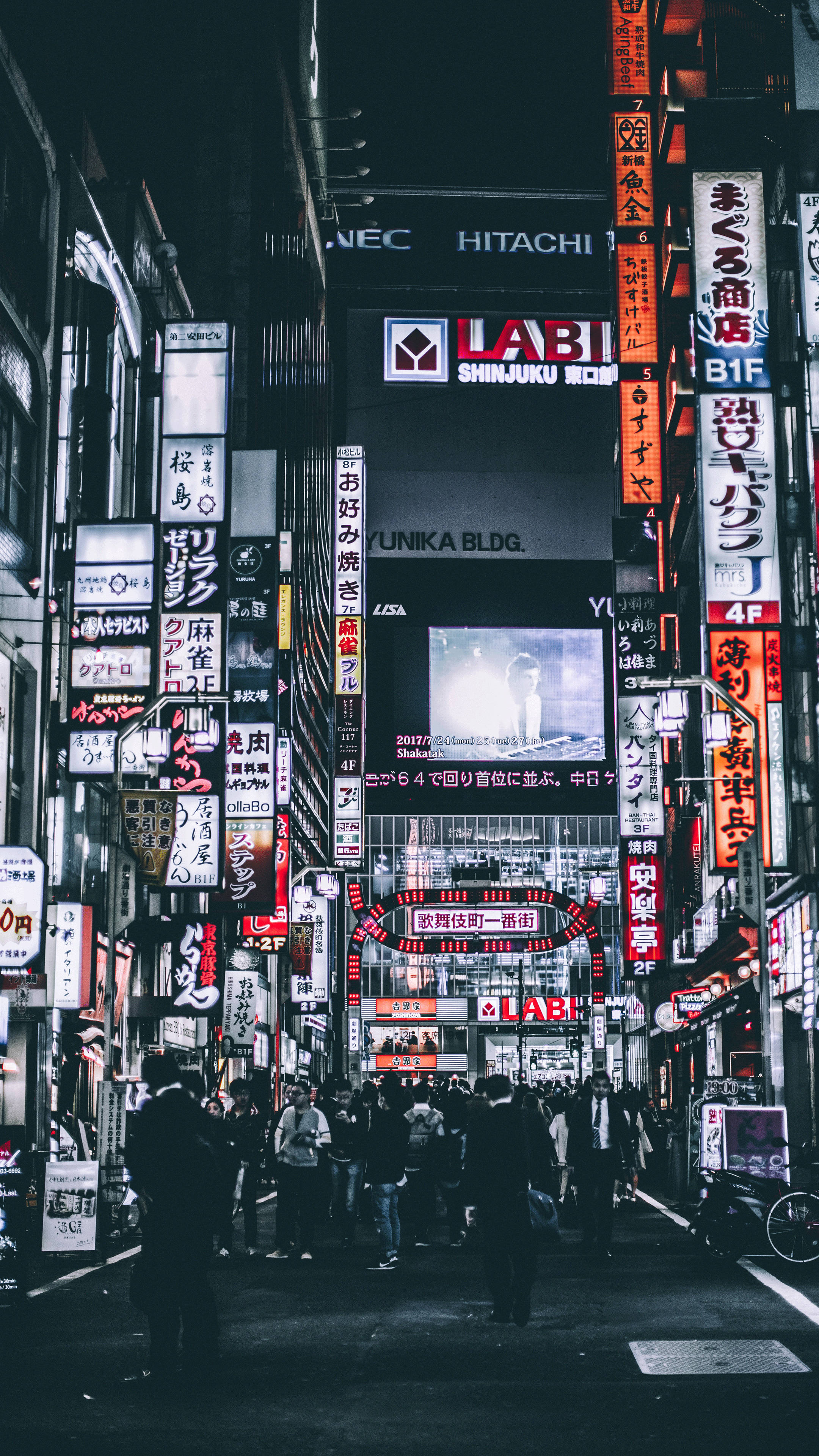 日本 桌布 壁紙 — 夜晚東京繁華的霓虹燈街道，擠滿人群的行人路和高聳建築物覆蓋著發光的招牌。