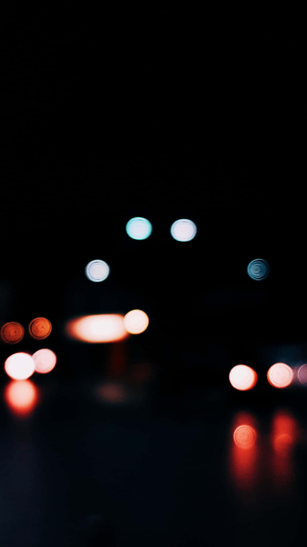 最佳高畫質 桌布 壁紙 — 夜晚汽車的散景燈光在潮濕的道路上形成紅色和藍色的發光球體。