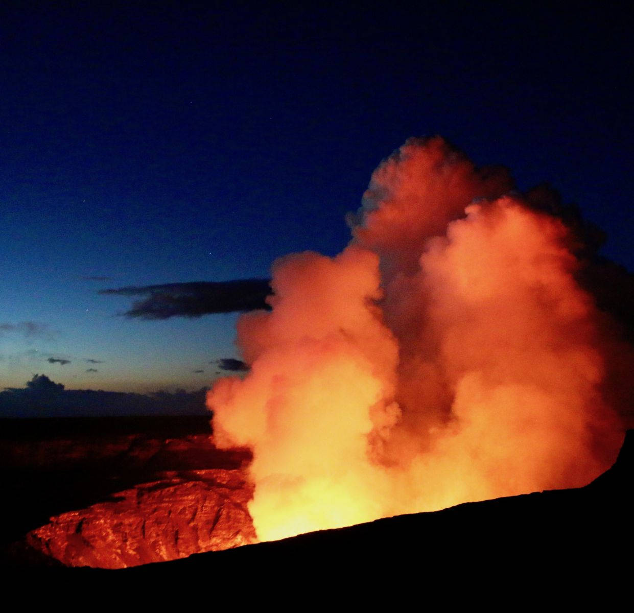自然 桌布 壁紙 — 夜晚火山爆發，將熾熱的橙色熔岩和煙霧噴射到深藍色的暮色天空中。