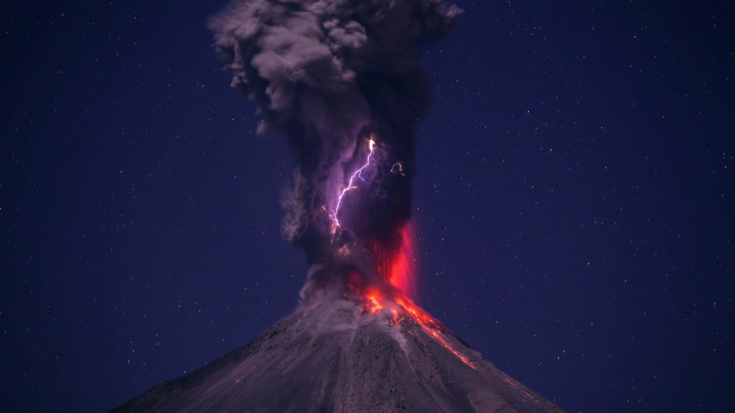 墨西哥 桌布 壁紙 — 夜晚火山爆發，熾熱的熔岩流動，閃電劃破濃煙，映襯著滿天星空。