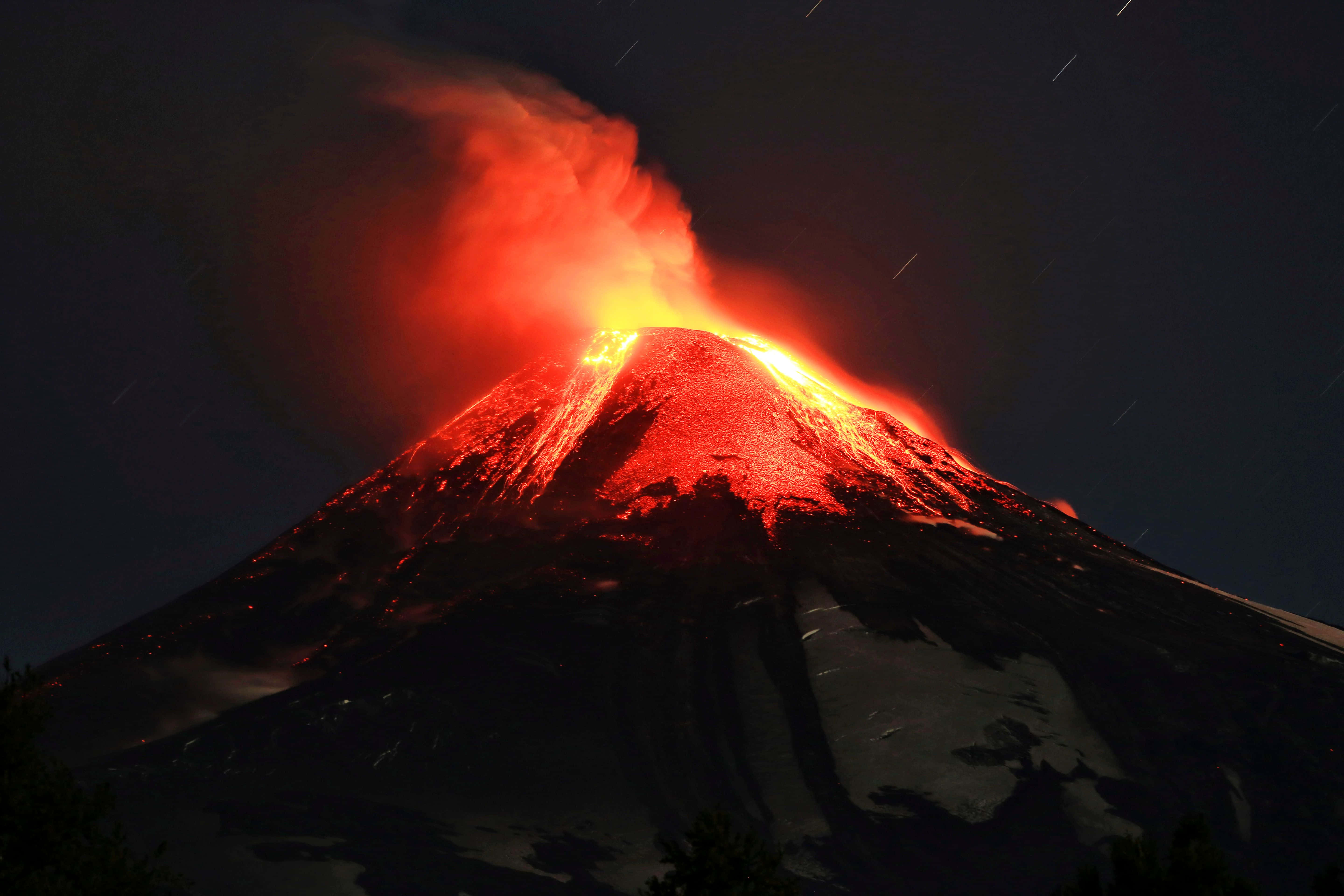 Volcano 桌布 壁紙 — 夜晚火山爆發，發光的熔岩和煙霧映襯著星空。