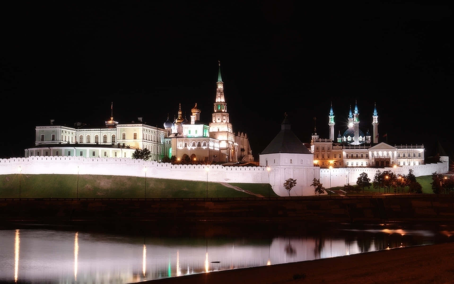 Moscow 桌布 壁紙 — 夜晚燈光璀璨的克里姆林宮建築群，發光的圓頂和宣禮塔倒映在平靜的河水上。