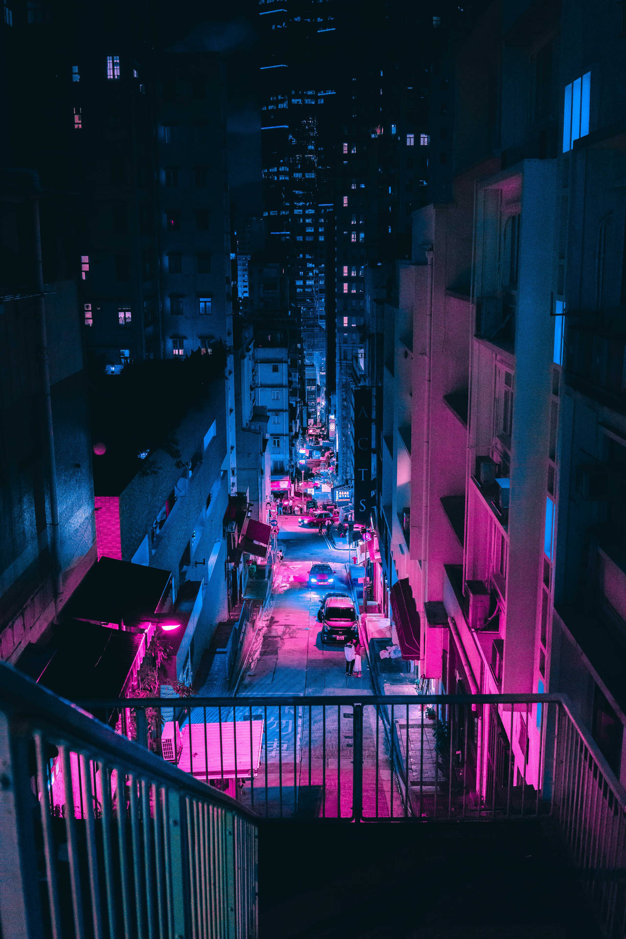夜晚霓虹燈照亮的小巷，粉紅色和藍色的燈光反射在潮濕的路面上。 — Google pixel 壁紙