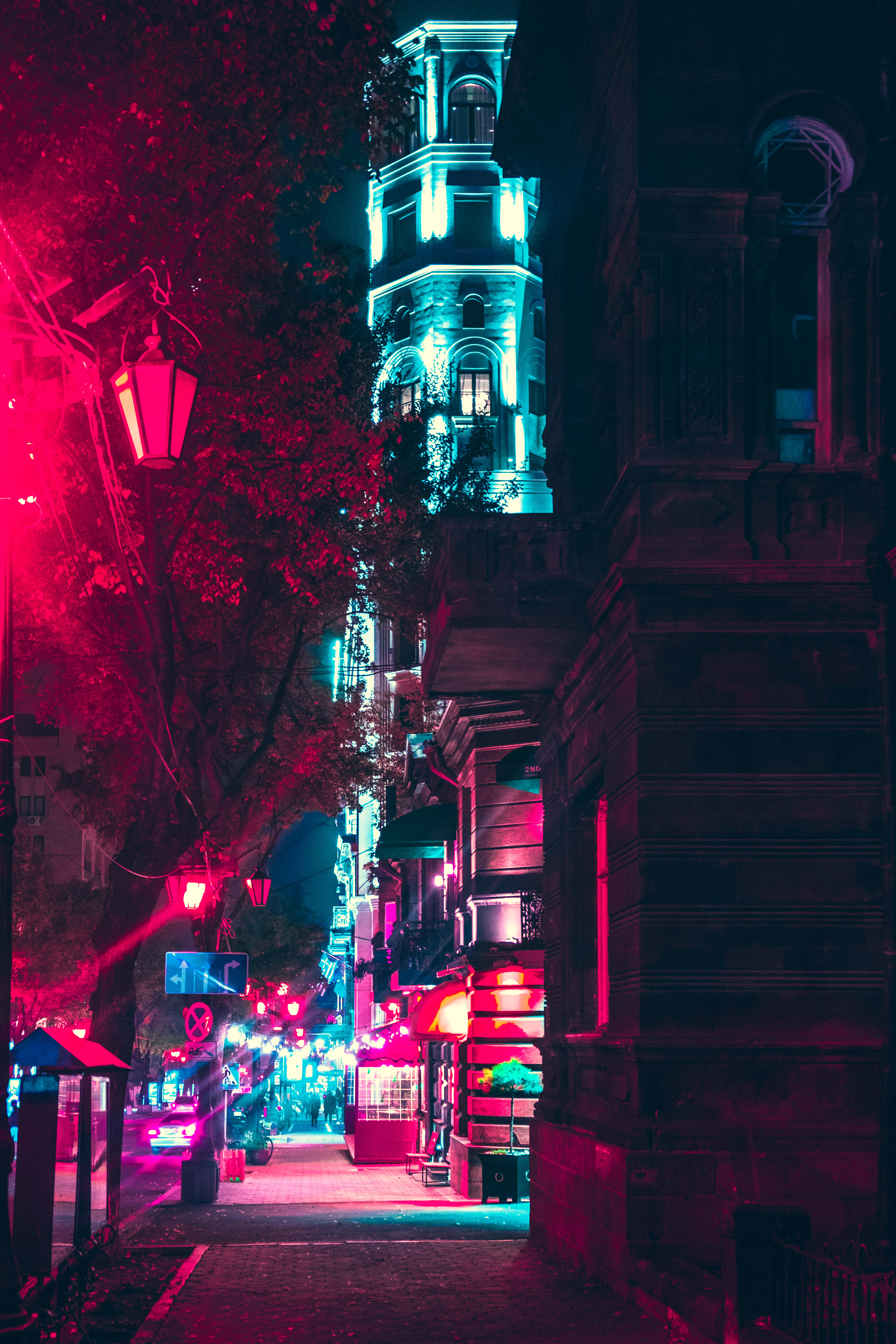 Neon City Aesthetic 桌布 壁紙 — 夜晚狹窄的城市小巷，被街燈和高聳建築物的鮮豔紅色和青色霓虹燈光沐浴。