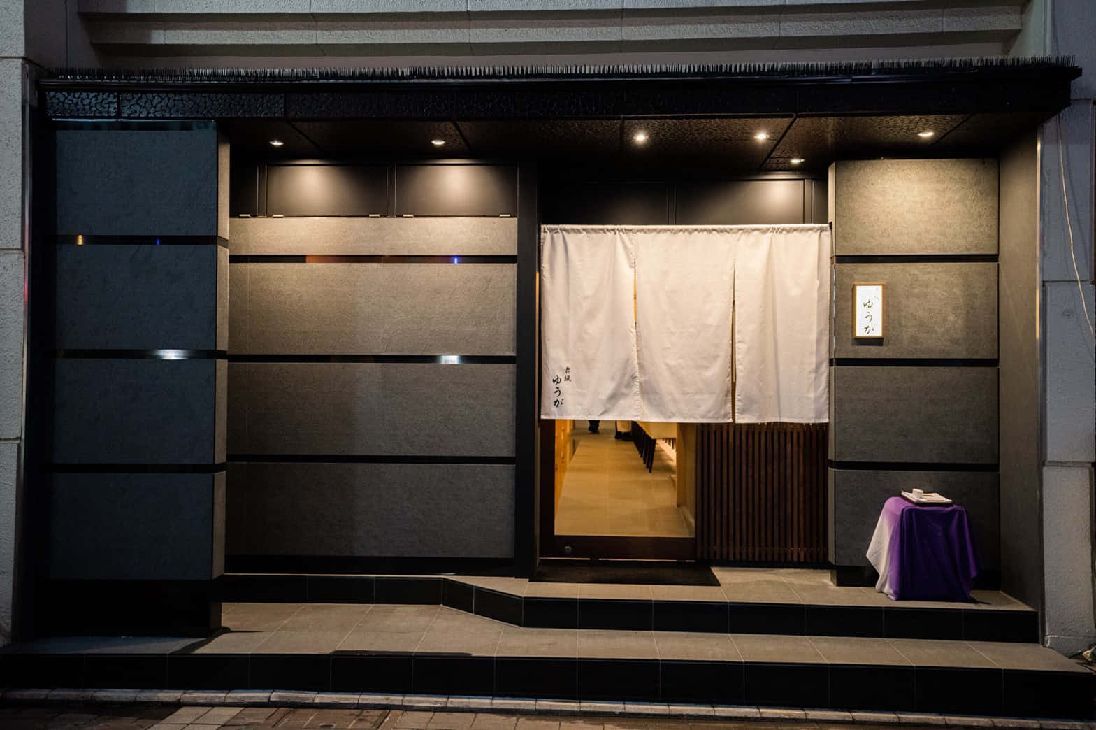 Tokyo Japan 桌布 壁紙 — 夜晚現代日本餐廳入口，白色暖簾在聚光燈下溫暖發光。