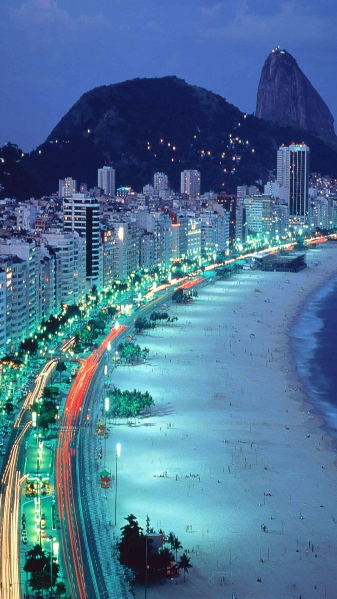 夜晚的城市，沙灘與山巒相伴 壁紙