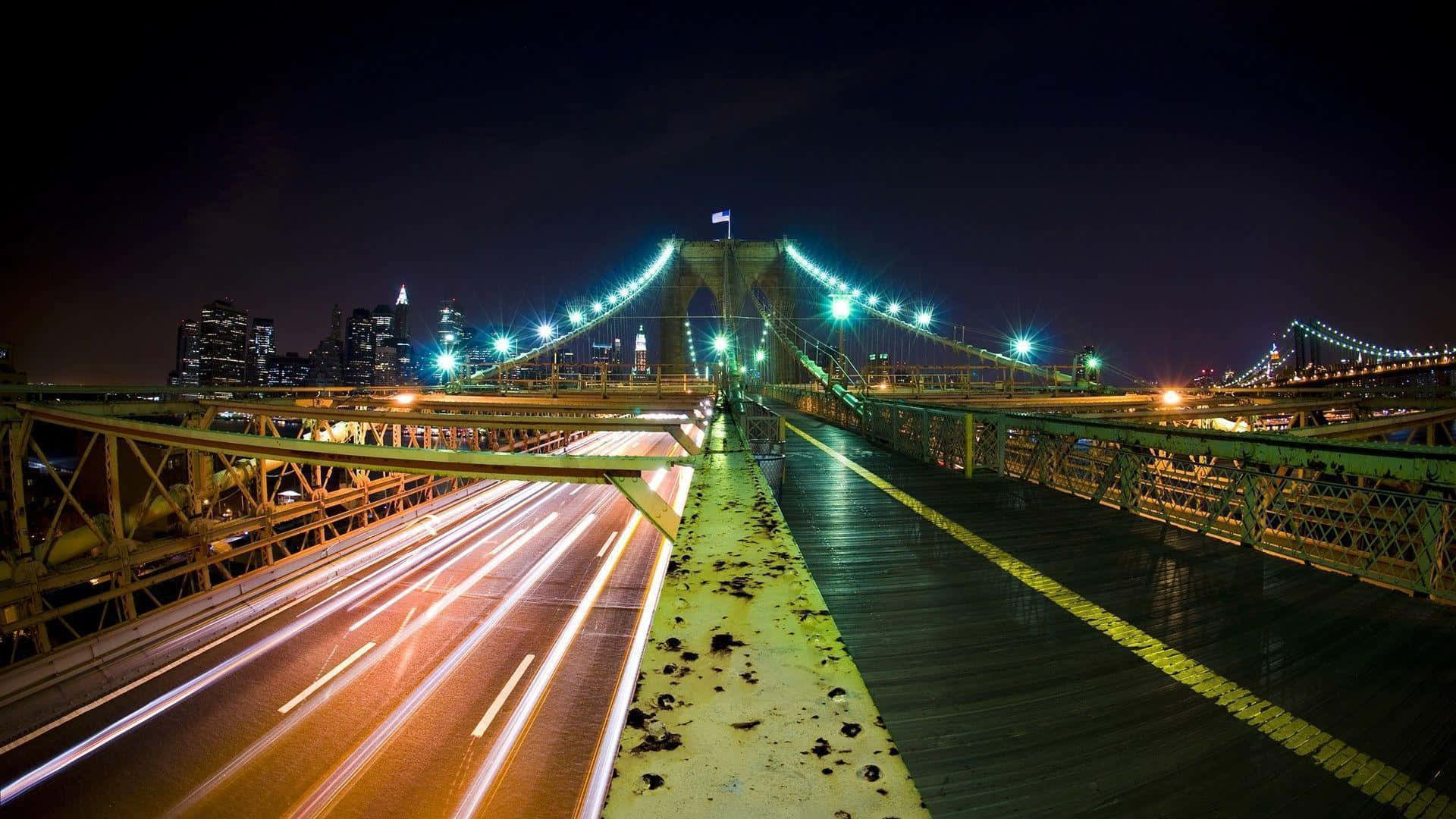 Scenic Desktop 桌布 壁紙 — 夜晚的布魯克林大橋，在黑暗的天空下閃爍著綠色光芒和汽車拖曳的光軌。