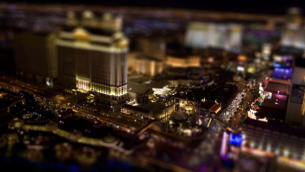 720p Las Vegas 桌布 壁紙 — 夜晚的微型城市景觀，帶有發光的燈光和模糊的建築，營造出夢幻般的都市場景。