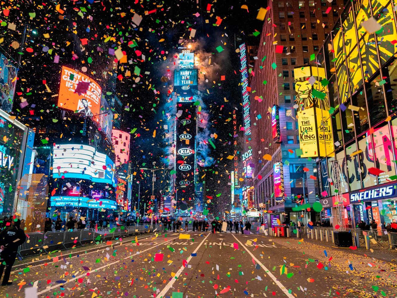 New Years Eve 桌布 壁紙 — 夜晚的時代廣場爆發出飄落的五彩紙屑和耀眼的數位廣告牌，慶祝除夕。