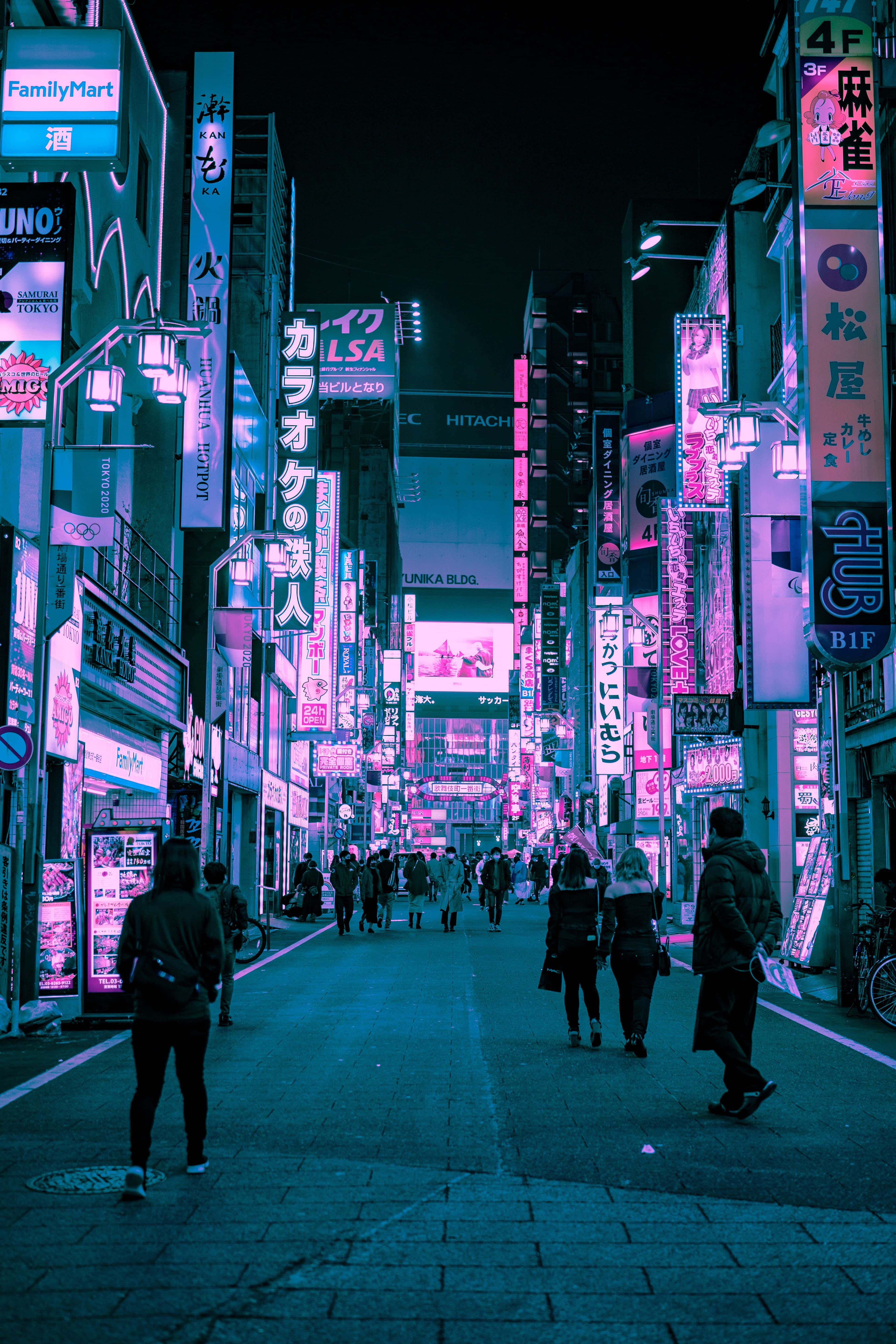 Retro Futurism 桌布 壁紙 — 夜晚的東京小巷充滿霓虹燈光，粉紅色和藍色的招牌在潮濕的人行道上反射，行人漫步在高聳的建築物下。