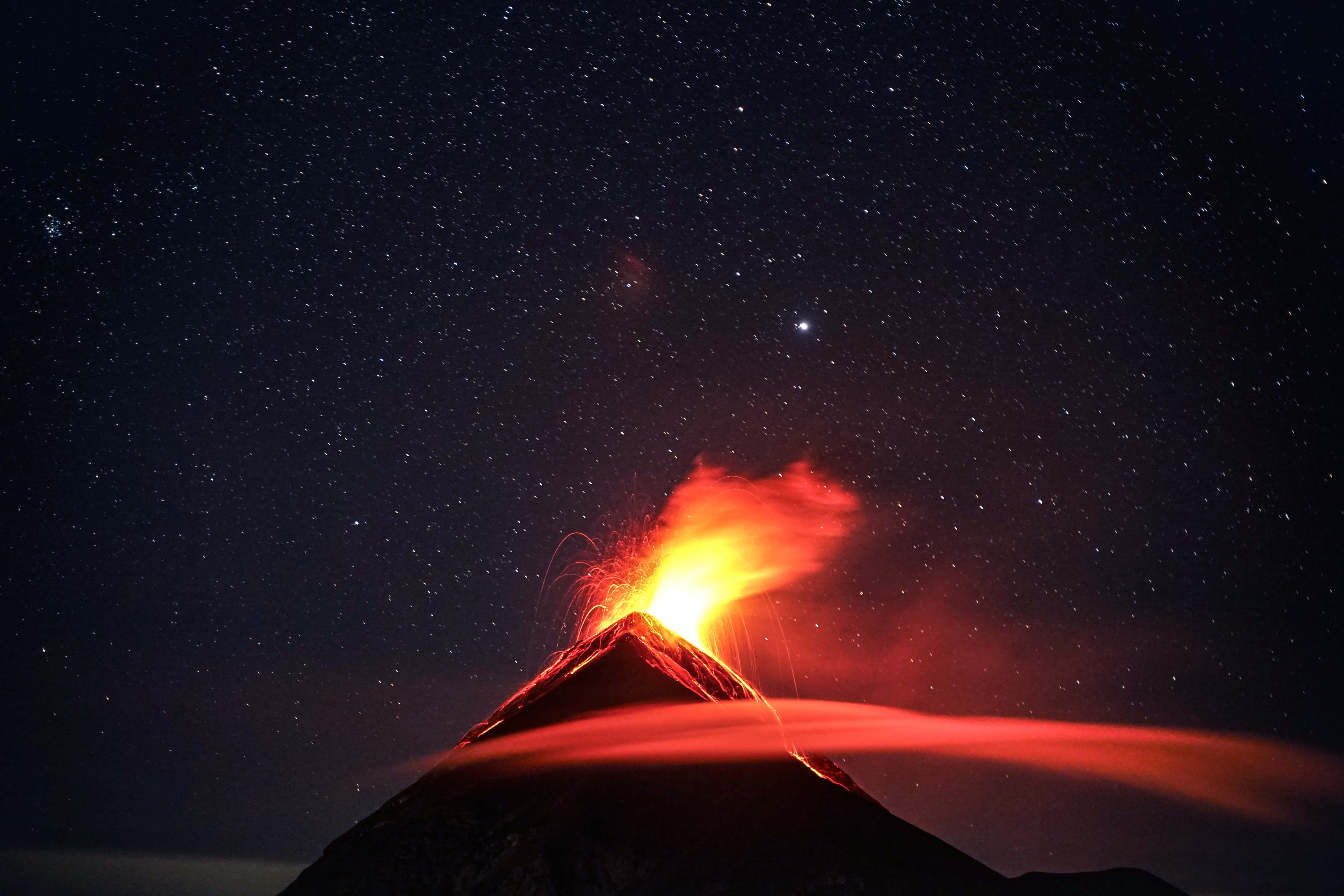 Volcano 桌布 壁紙 — 夜晚的火山爆發，以星空為背景，用熾熱的熔岩和發光的灰燼照亮天空。
